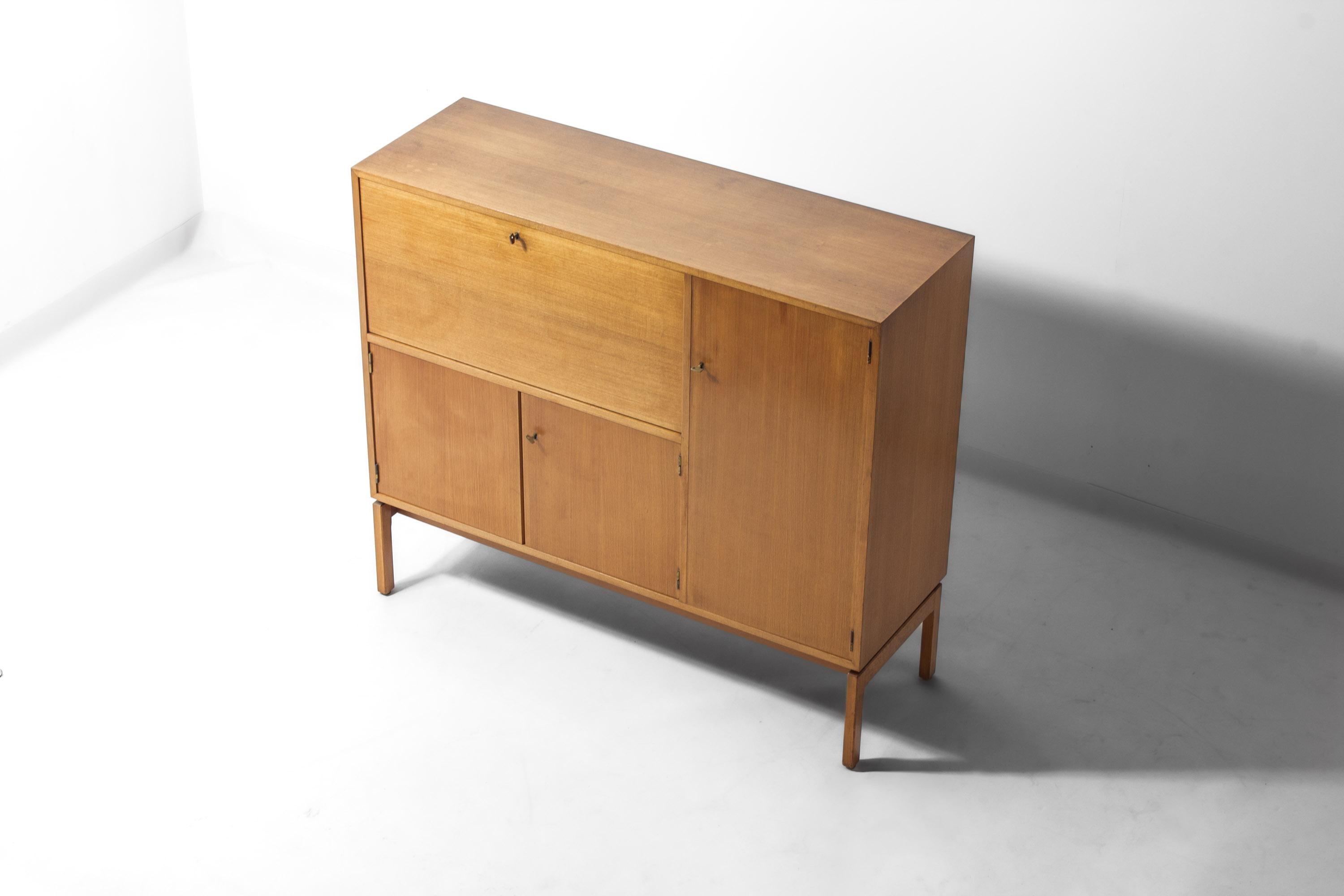 Mobile bar progettato da Jos De Mey come parte della serie Abstracta, prodotta da Van den Berghe-Pauvers a Gand, in Belgio, negli anni '60. Il mobile è realizzato in rovere chiaro e poggia su una base rettangolare rialzata. Presenta un vano bar a