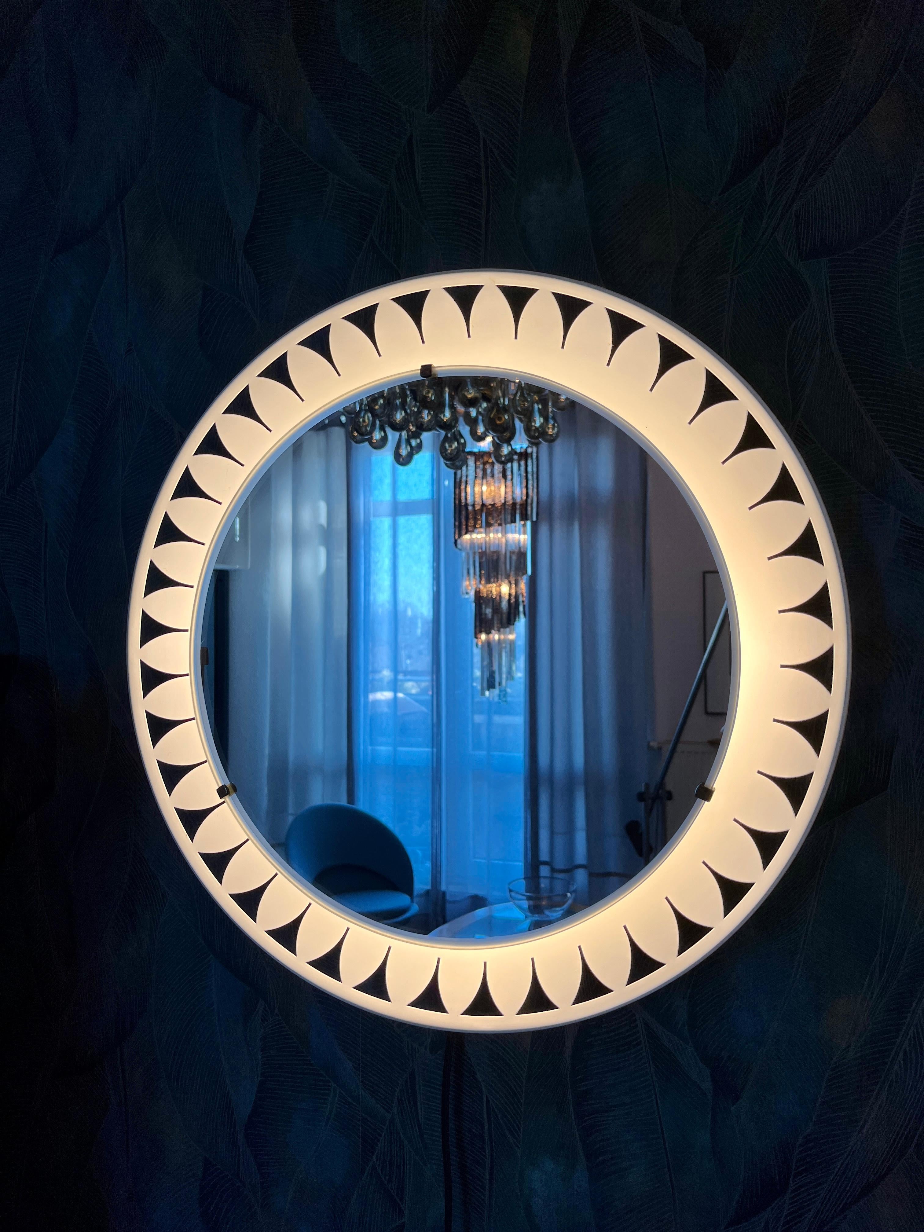 A wall mirror with indirect lighting from the German manufacturer Hillebrand Lighting. It was manufactured in the 1970s. The frame contains four E14 light bulbs (max. 40W). The mirror frame and base are made of metal.
This vintage item is fully