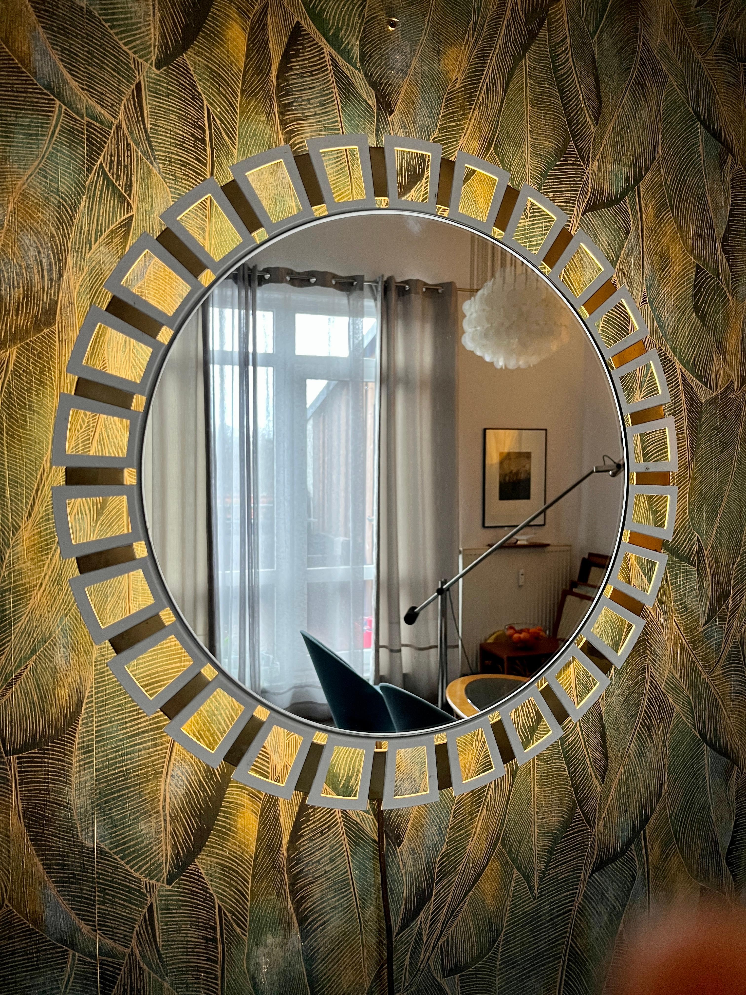 A wall mirror with indirect lighting from the German manufacturer Hillebrand Lighting. It was manufactured in the 1970s. The frame contains four E14 light bulbs (max. 40W). The mirror frame and base are made of metal.
This vintage item is fully