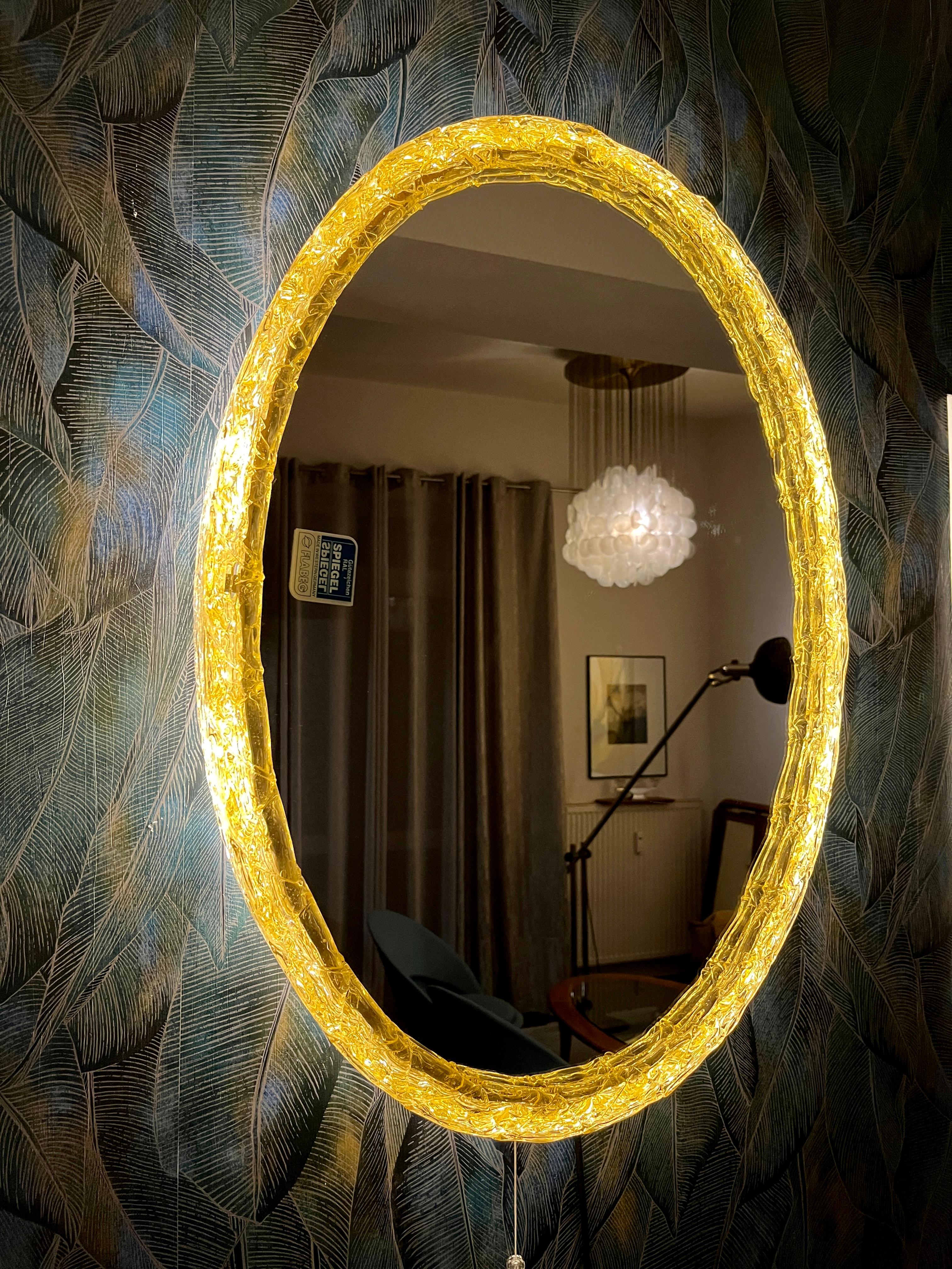 A wall crystal mirror with indirect lighting from Flabeg.. It was manufactured in the 1970s. The frame contains four E14 light bulbs (max. 40W).
The mirror frame is made of acrylic, and the frame is made of metal.
This vintage item is fully