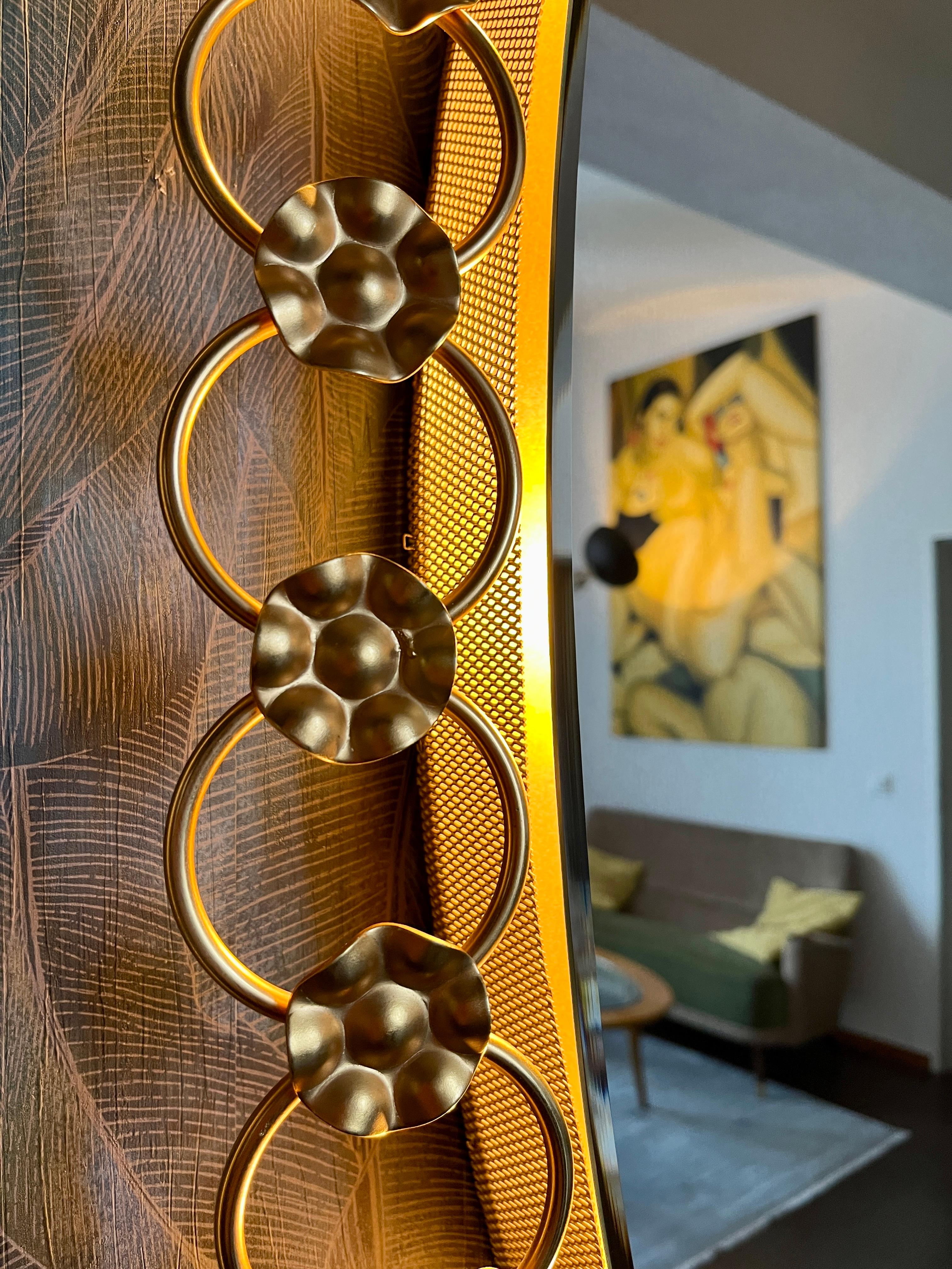 A wall mirror with indirect lighting from the German manufacturer Spiegelunion Flabeg. It was manufactured in the 1970s.
The frame accommodates 6 E14 light bulbs (max. 40W).
The mirror frame is made of brass, and the frame is made of wood and