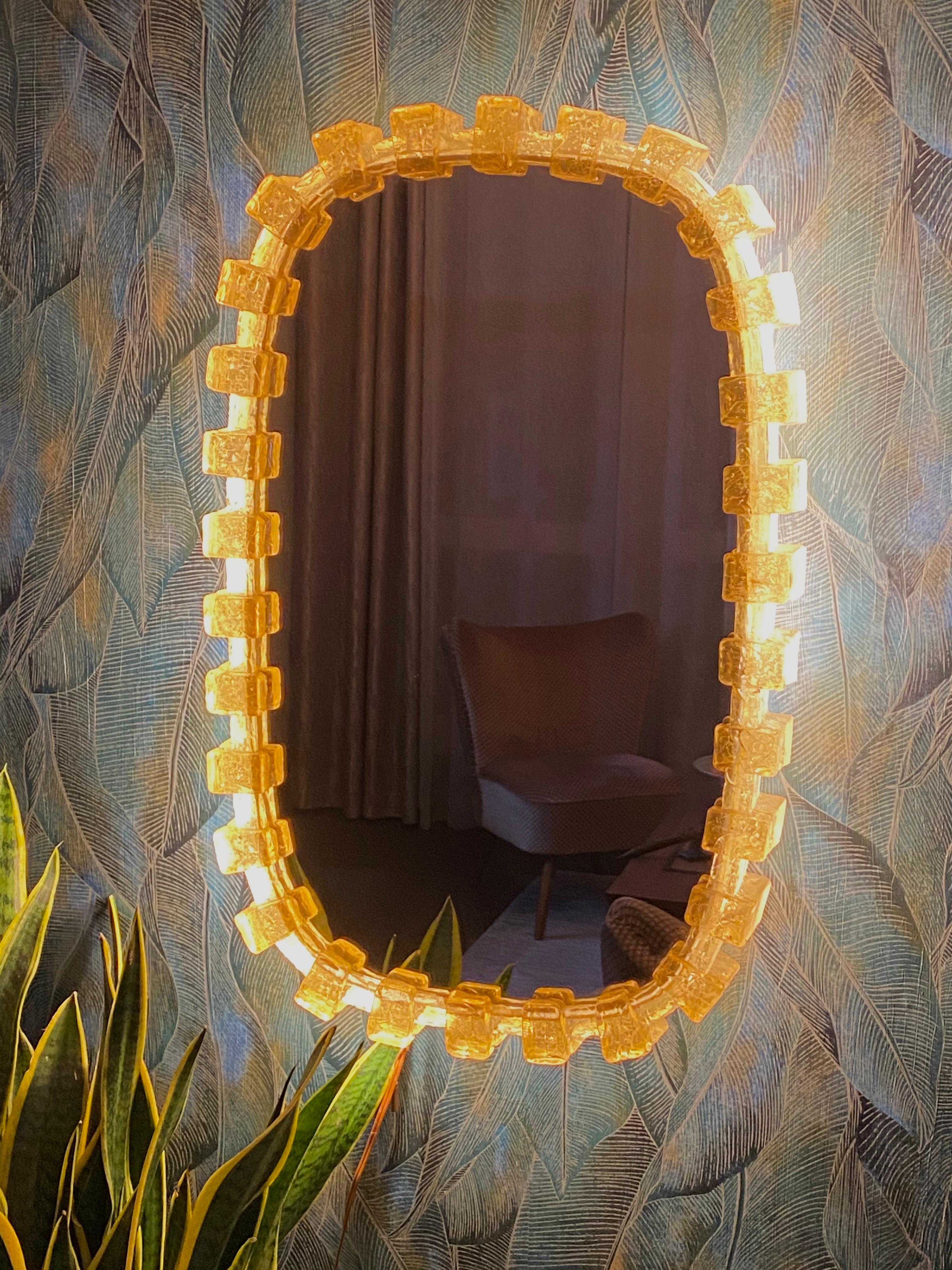 A wall mirror with indirect lighting from the German manufacturer Hillebrand Lighting. It was manufactured in Germany in the 1970s. The mirror frame is made of acrylic and the base is made of metal. Perfect for a dressing room, bedroom, or living
