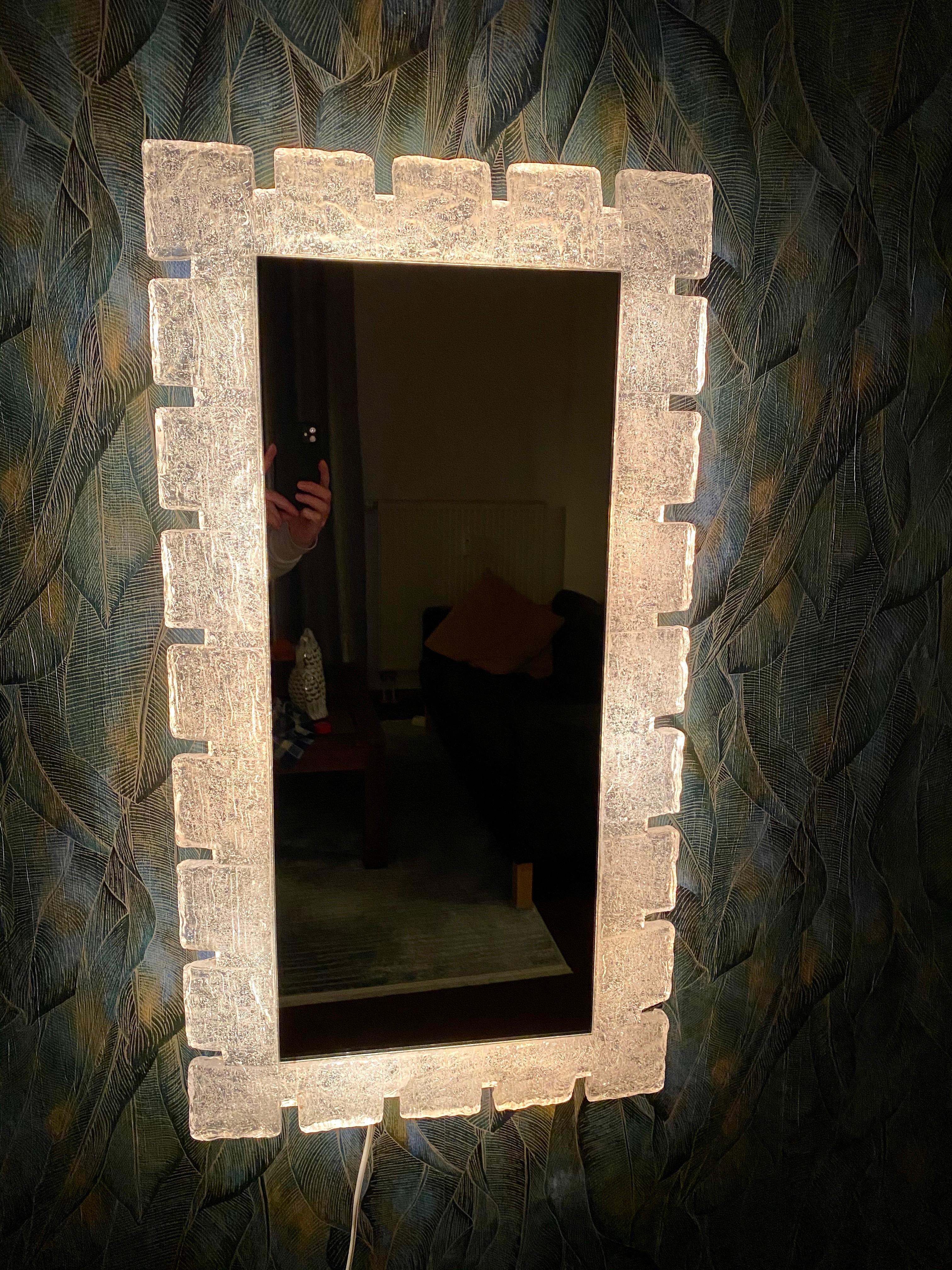 A wall mirror with indirect lighting from the German manufacturer Hillebrand Lighting. It was manufactured in the 1970s.
The frame accommodates 8 E14 light bulbs (max. 40W). The mirror frame is made of acrylic, and the frame is made of metal.
This