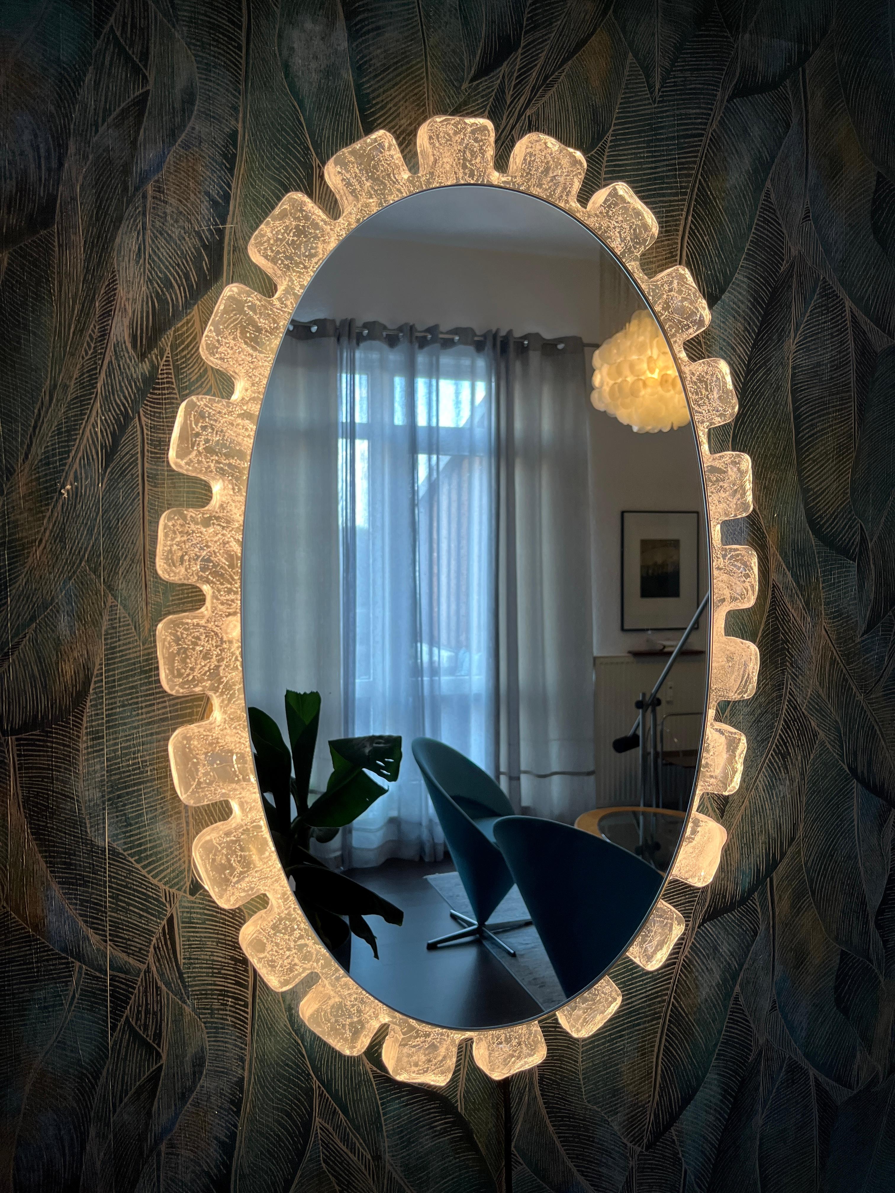 Un grande specchio da parete con illuminazione indiretta del produttore tedesco Hillebrand Lighting. È stato prodotto negli anni '70. La struttura contiene quattro lampadine E14 (max. 40W).
La cornice dello specchio è in vetro acrilico e il telaio è