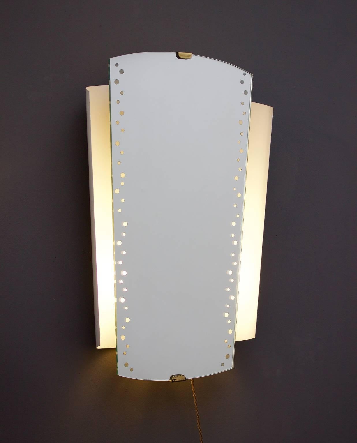 *** Spring sale***

Illuminated mirror by Ernst Igl for Hillebrand, Germany. Manufactured 1964 (date stamped on reverse of glass).

The off-white lacquered metal frame is wall-mounted, with the mirror glass set in brass clips top and bottom; light