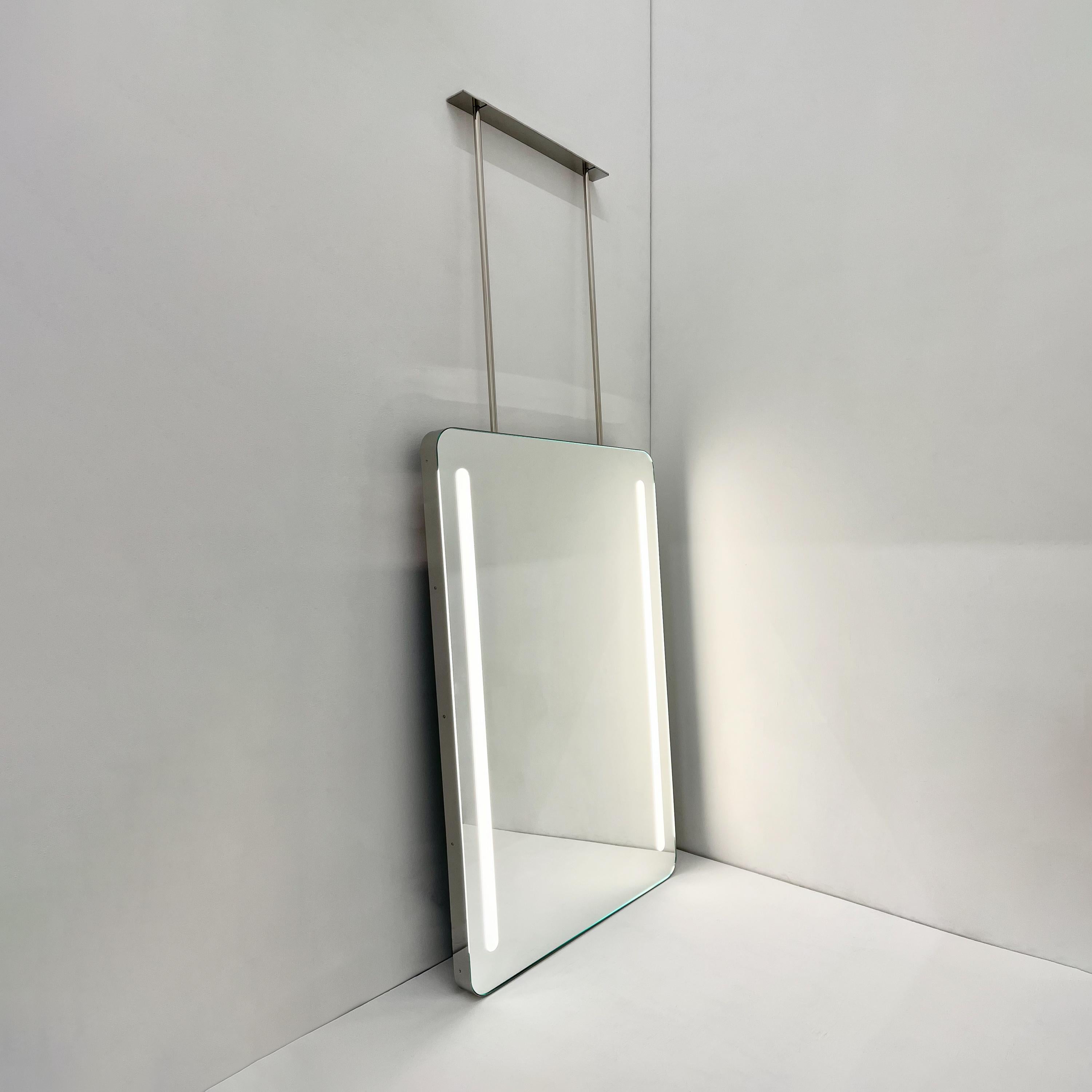 Contemporary ceiling hanging Quadris™ rectangular mirror with a polished Stainless Steel frame and front illumination. Designed and handcrafted in London, UK. This mirror is fully customisable to suit the specific requirements of each