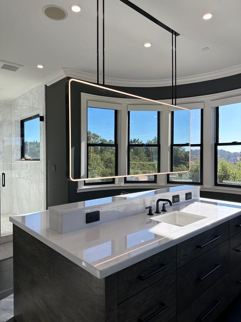Oversized modern ceiling suspended Quadris™ front illuminated rectangular double sided mirror with a handcrafted blackened metal frame. Ideal for bathroom islands or to create a design statement in any room of the house. Designed and handcrafted in
