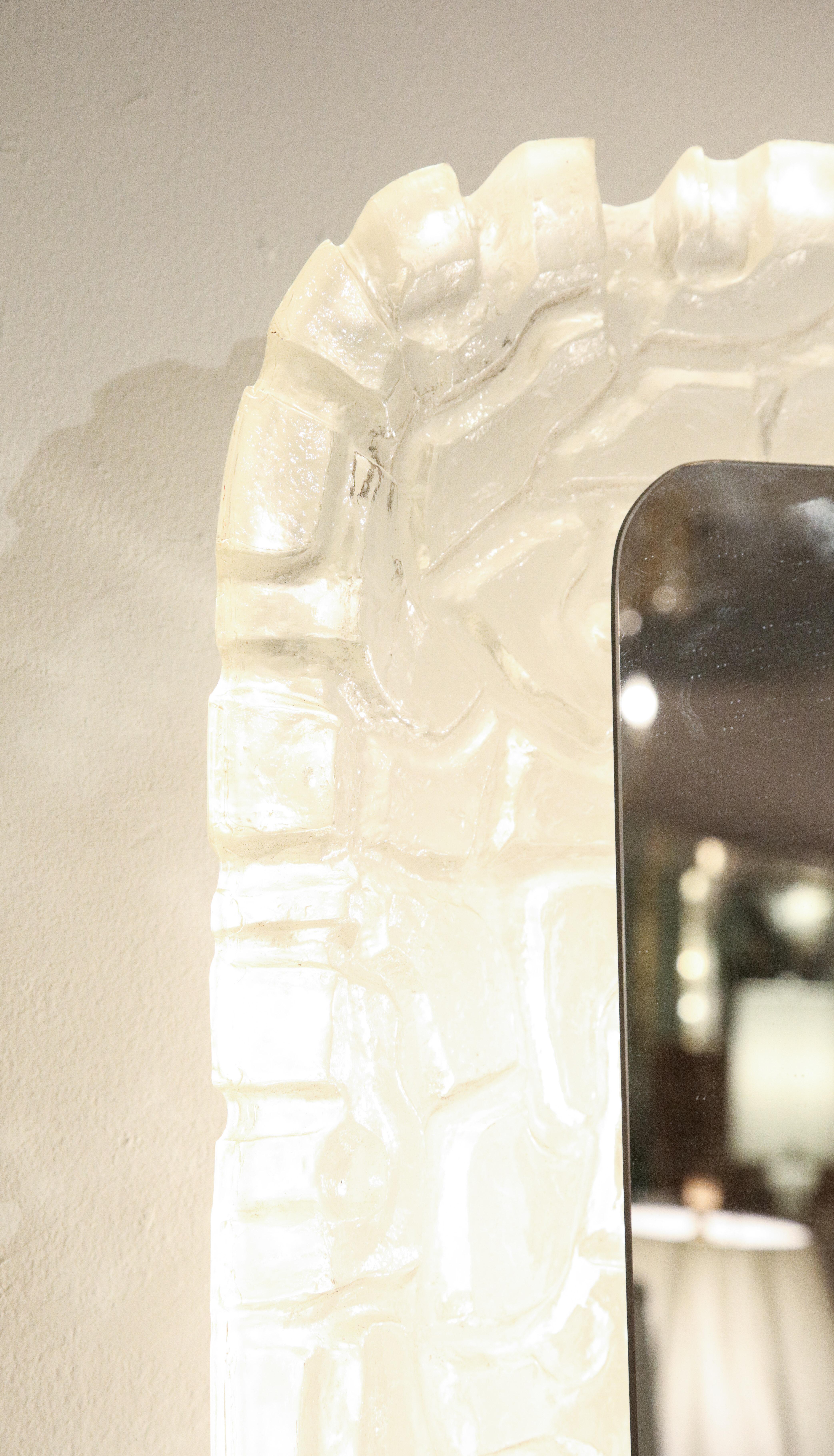 A great illuminated rectangular mirror with molded frame with scalloped edges   resembling frosted glass. The  frame is substantial and deep to hide the bulbs. Looks great both lit and not lit.