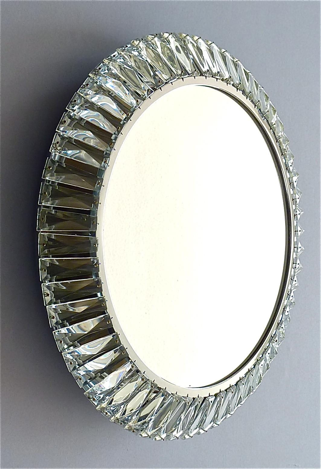 Round chrome brass metal faceted crystal glass backlit wall mirror made by Palwa, Germany, circa 1960-1970, documented in the Palwa sales catalog. The frame has lots of beautiful hand-cut faceted and polished crystals in the shape of a diamond