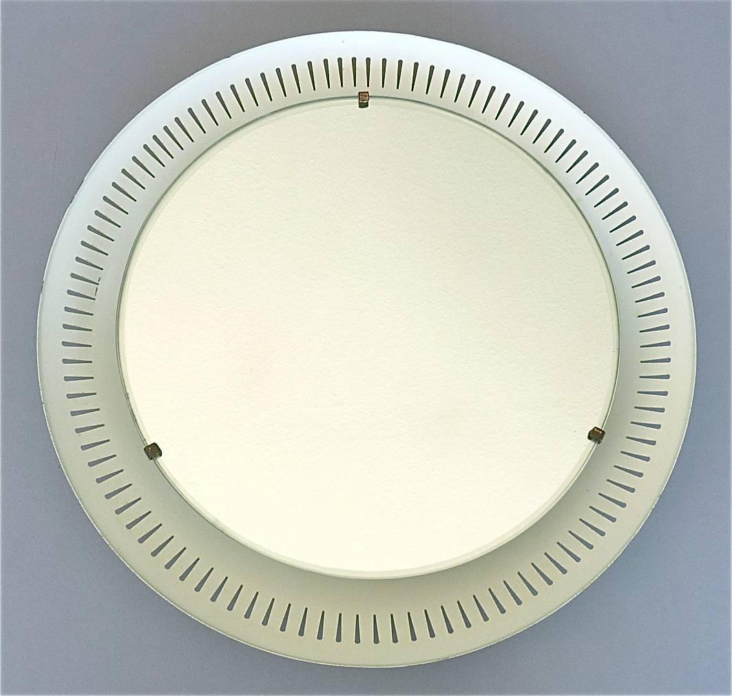 Stunning midcentury round Italian backlit wall mirror executed in the 1950s with attribution to one of the famous companies and designers Stilnovo, Arteluce and Sarfatti. The circular illuminated mirror which has a total width of 47 cm / 18.50