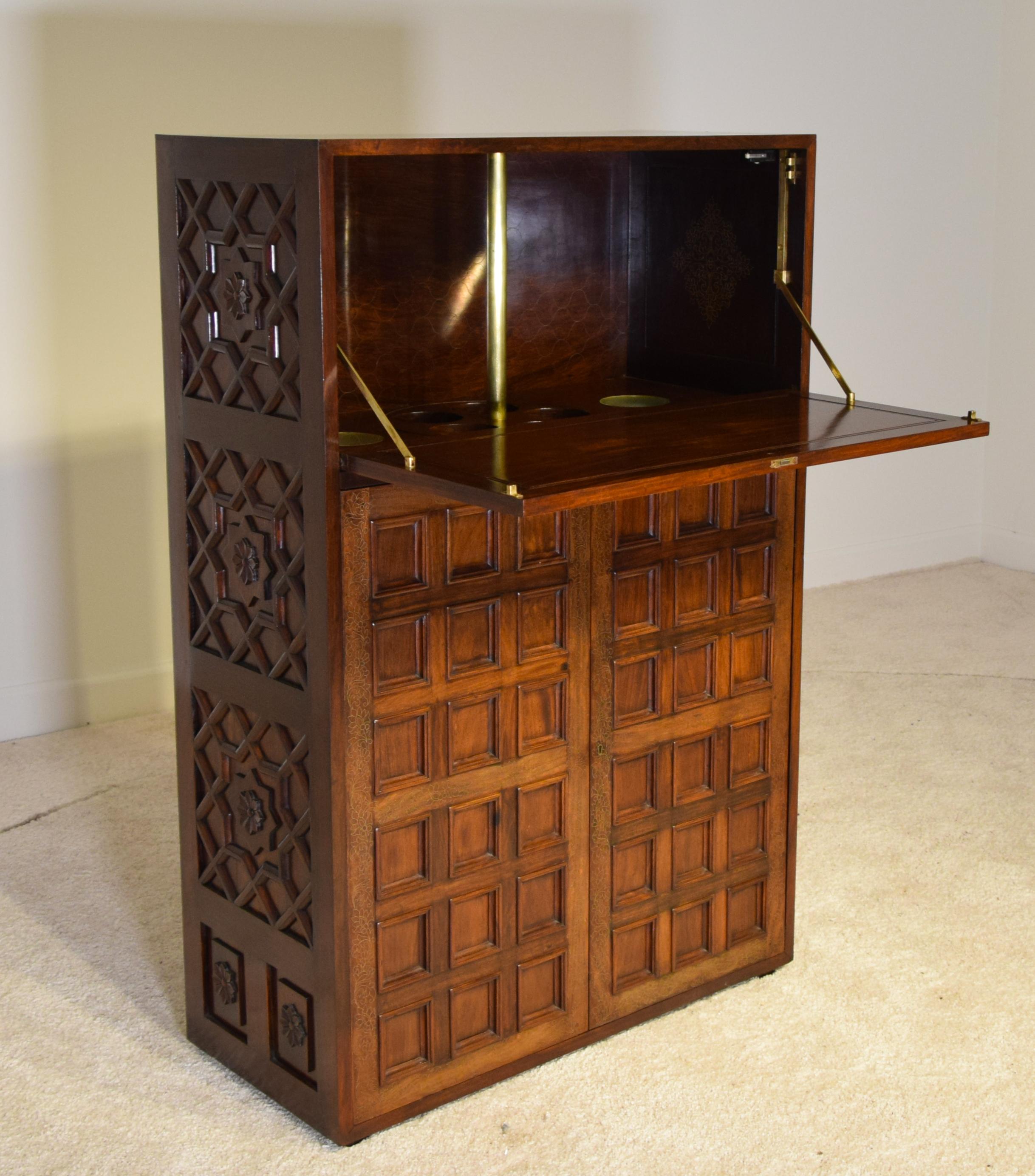 Rare solid rosewood (no veneers). 
Measures: 46 tall x 30 wide and 13.75 inches deep.
20 photos are listed here.

Elaborate and intricate inlaid brass over the entire front borders as well the interior of the fall table top where a rotating