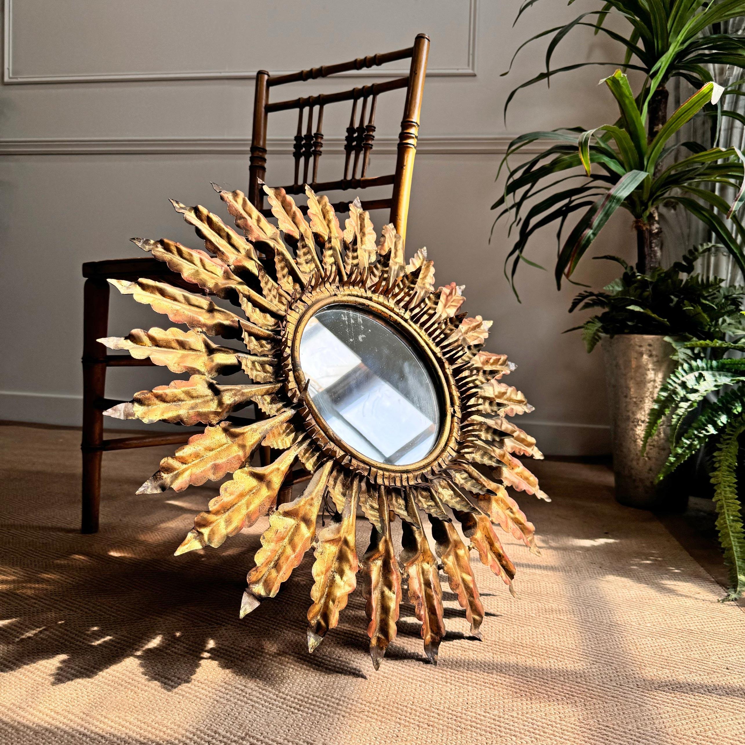 Este hermoso espejo de sol iluminado de hierro de los años 30 en su acabado dorado original, dorado en muchas zonas se alimenta de tonos cobrizos y verdes metálicos.

Se ilumina por detrás con dos portalámparas edison dorados e14 (de rosca pequeña),