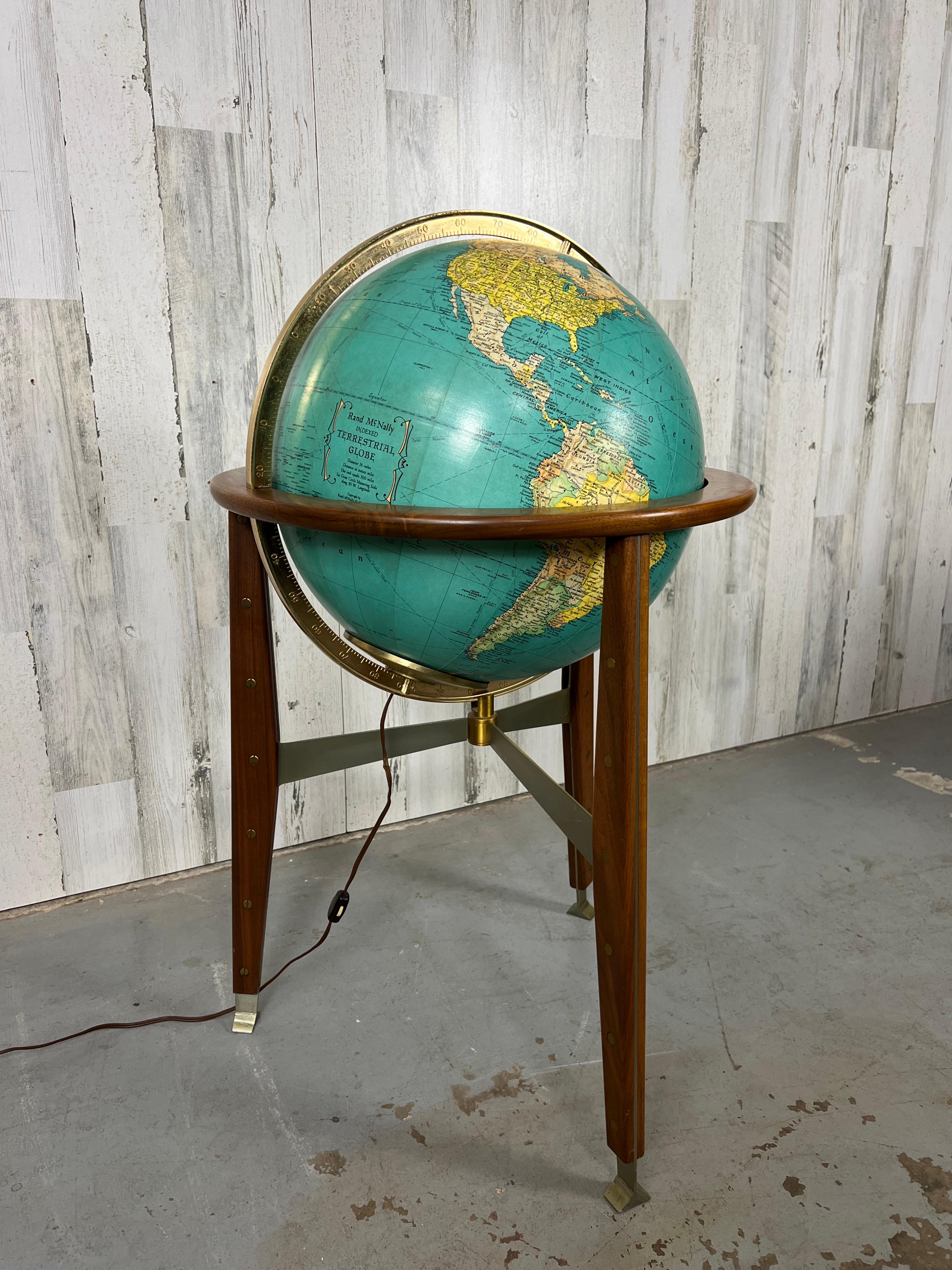 Stainless steel sandwiched by solid walnut saber legs, fastened with stud and screws make this globe base equally stunning as the globe it self. The illuminated glass globe is covered with a Rand McNally terrestrial map.