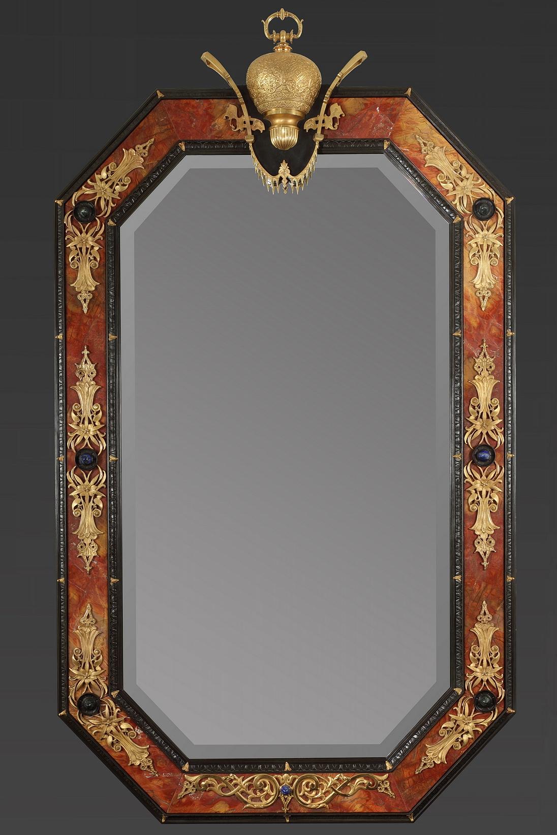 Large octogonal illuminating mirror in rosso antico marble and silvered bronze, decorated with gilt bronze garlands and semi-precious stones such as lapis-lazuli, porphyry.

It is part of a serie of six mirrors, made by our workshops. This one bear