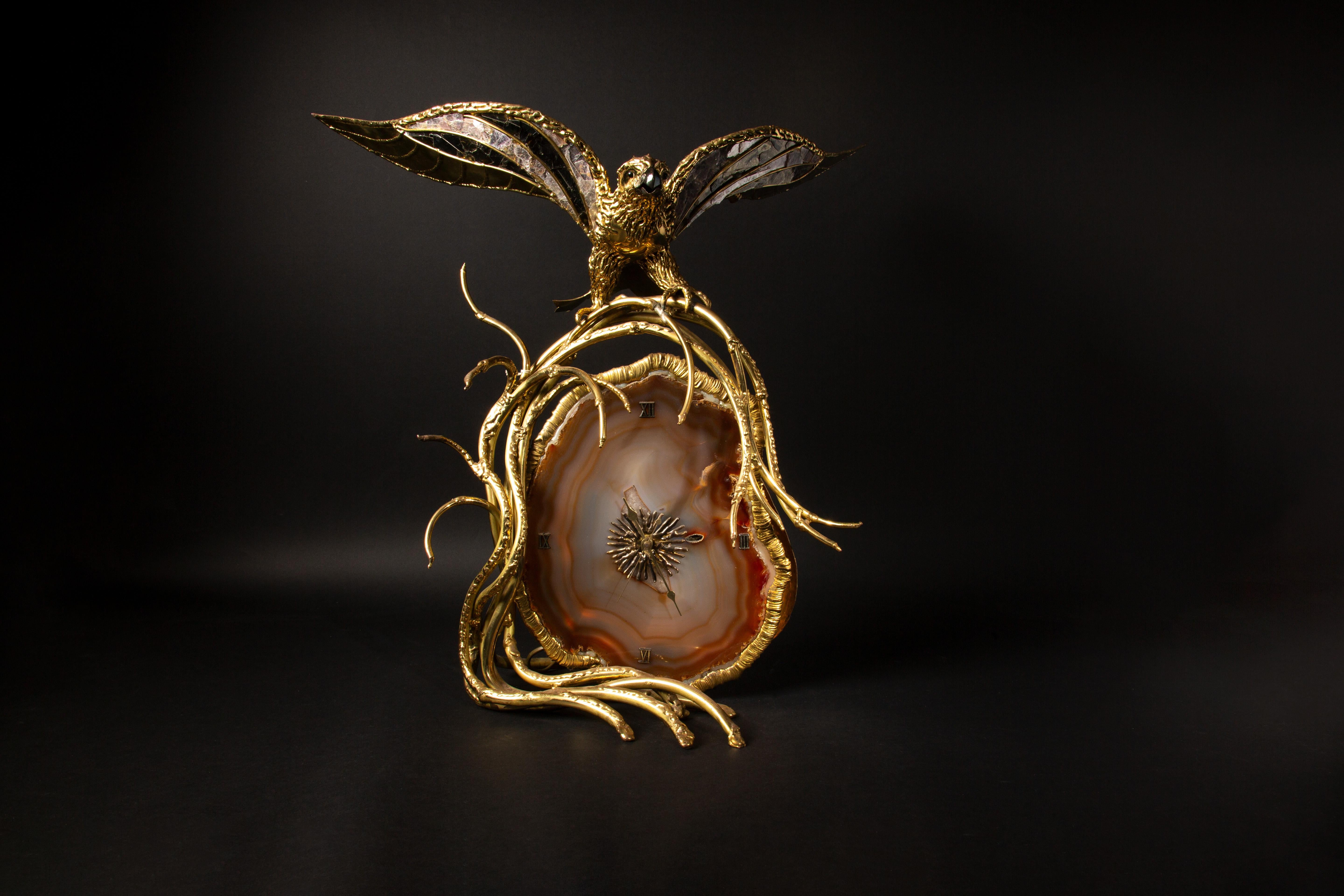 FAURE (Richard and Isabelle): Large illuminating clock\sculpture crafted from gilt brass and agate, adorned with a bird spreading its wings, highlighted with mica. Created by Richard and Isabelle Faure.

In the 1970s and 80s, Honoré Paris, founded