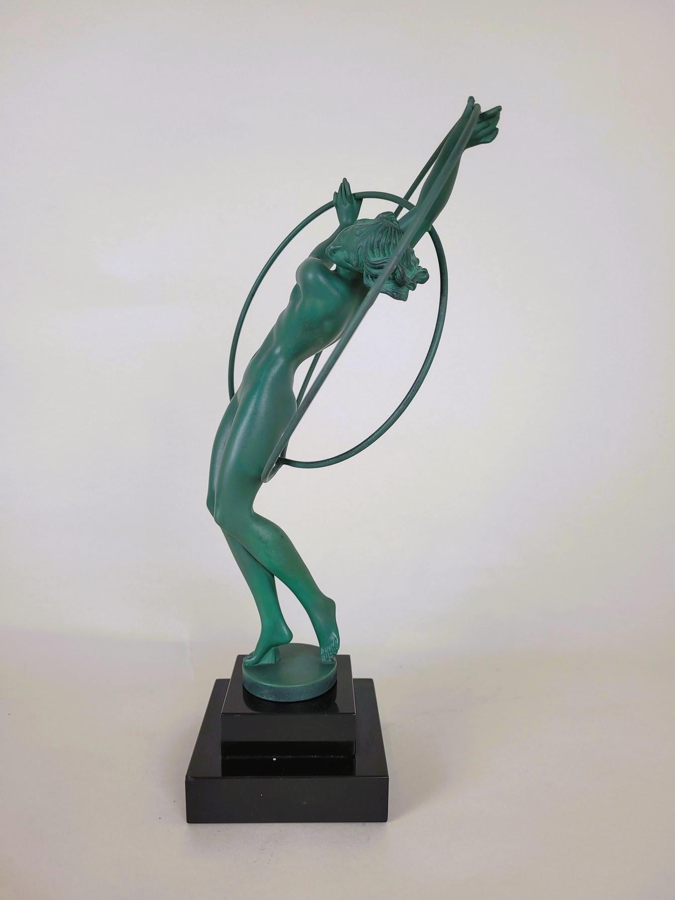 Illusion: Sculpture representing a naked dancer, playing with 2 hoops, standing on a stepped base in black marble

Green patina spelter, the base is signed by Fayral (pseudonym used by Pierre Le Faguays to sign his spelter creations) and published