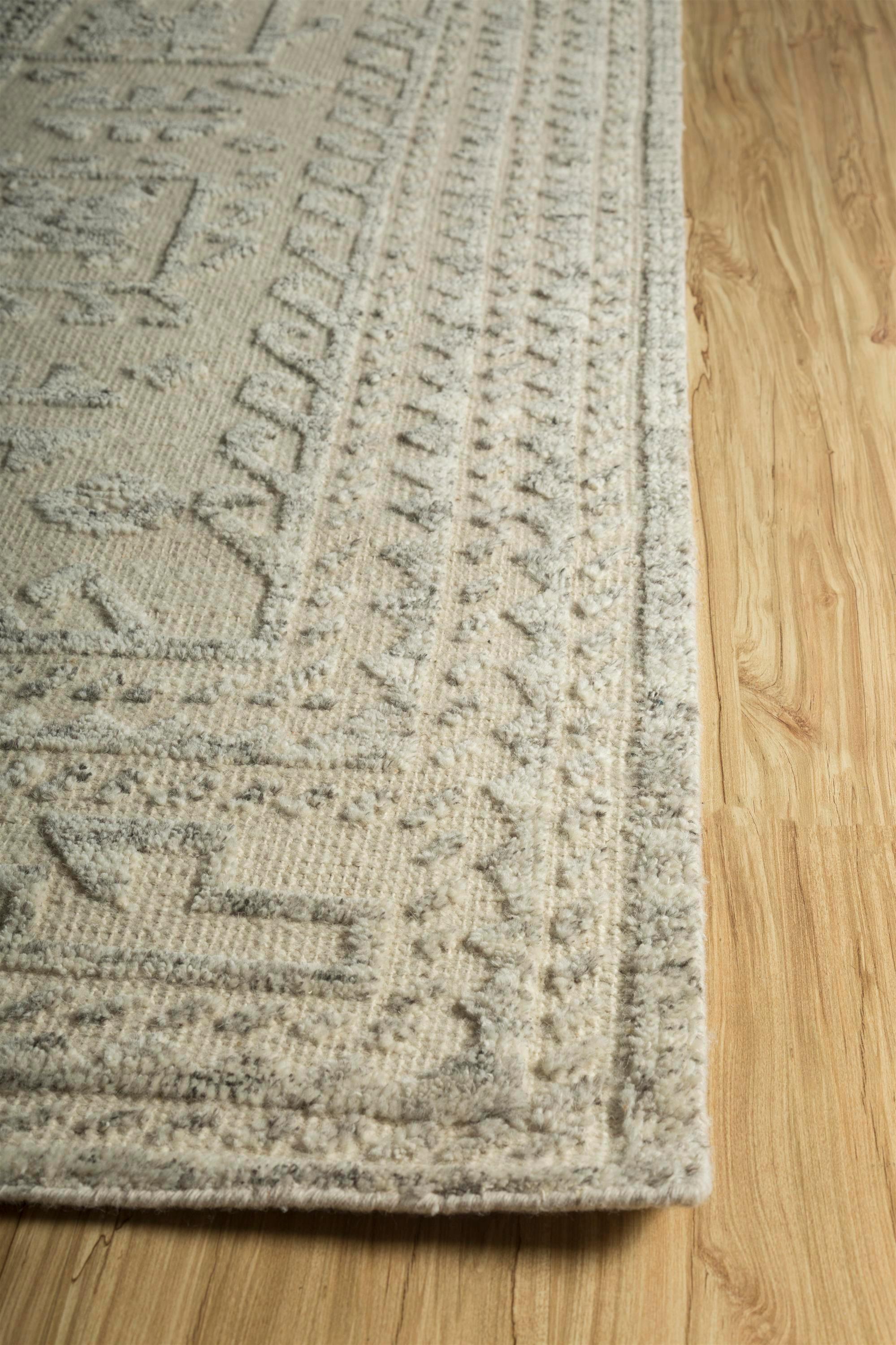 Dieser luxuriöse Teppich aus der Manifest Collection'S verbindet Eleganz mit natürlichem Charme. Die Grundlage des Teppichs ist mit einem beruhigenden, natürlichen Off-White-Farbton verziert, der an unberührten Schnee erinnert und ein Gefühl von