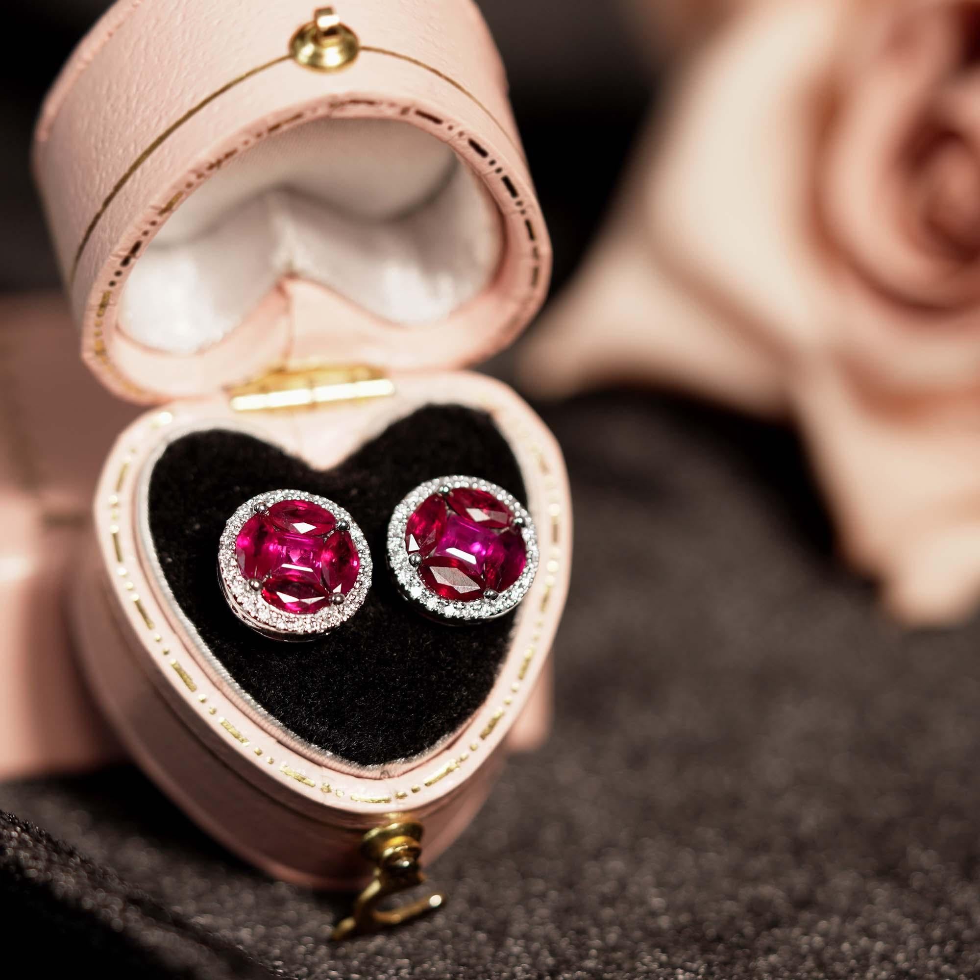 These eye-catching 18k contemporary stud earrings features an impressive white gold setting, centering multi-shaped rubies formed one 8 mm. size look-alike circle, accented by 0.21 carat of round brilliant cut white diamonds. The round shape halo