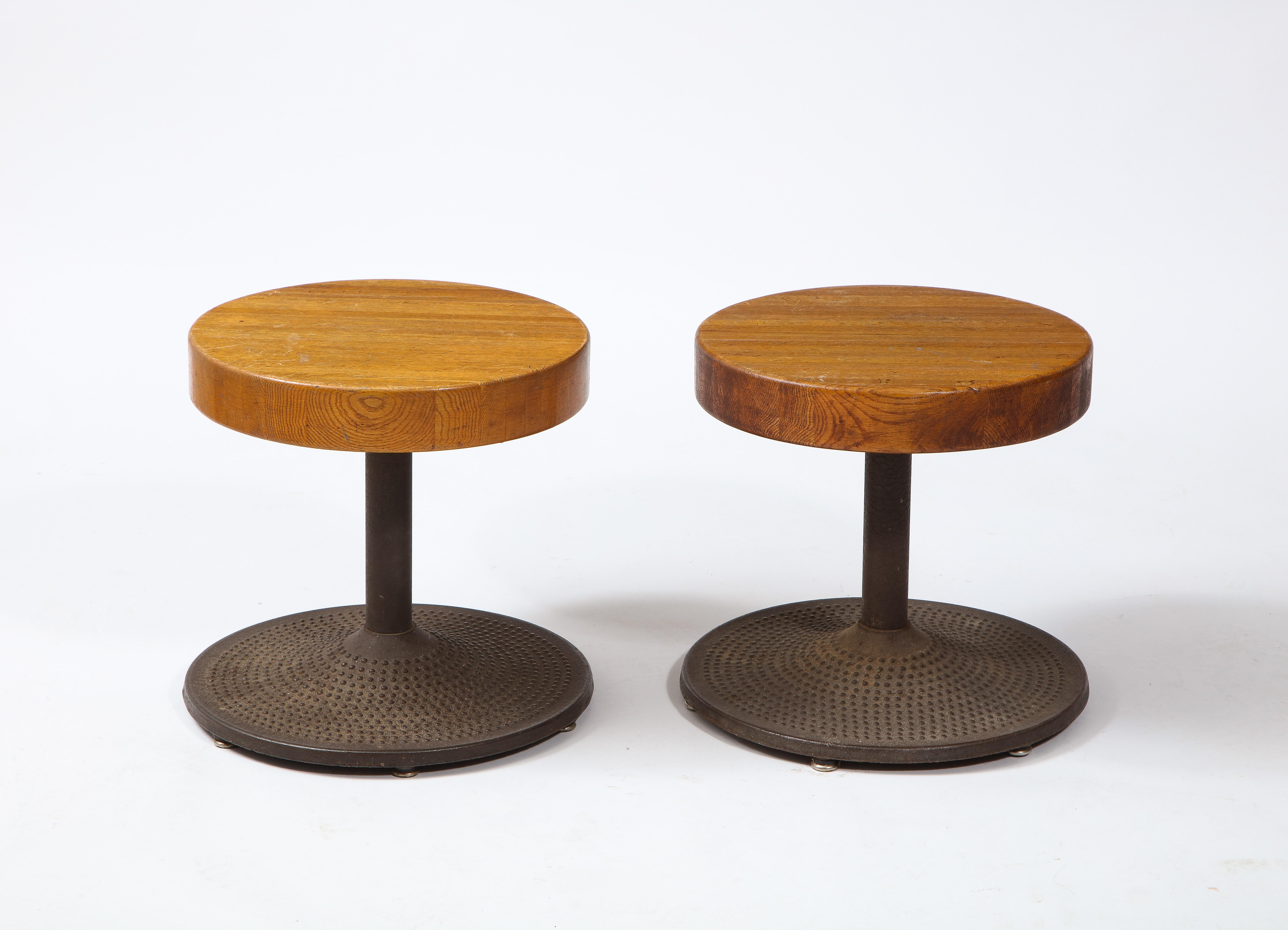 Fantastic pair of cast iron and oak stools, the bases are solid iron with a dimpled motif while the top are solid oak, the design bears similarity to a Perriand model for Les Arcs.