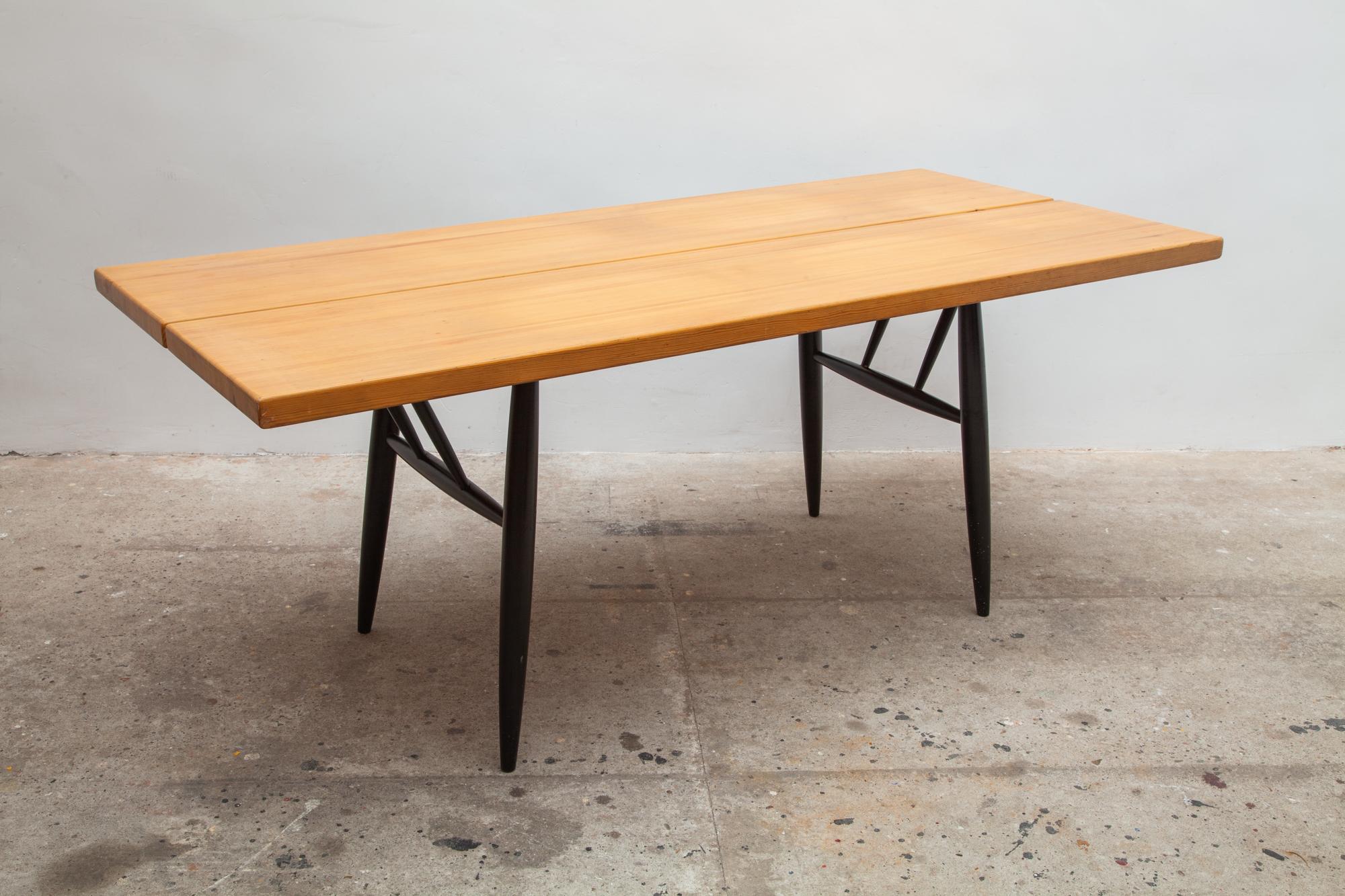 Pinewood solid large dining table designed by Ilmari Tapiovaara for Laukaan Puu, Finland 1955 with black lacquered dowel legs. The brand marked on the bottom.