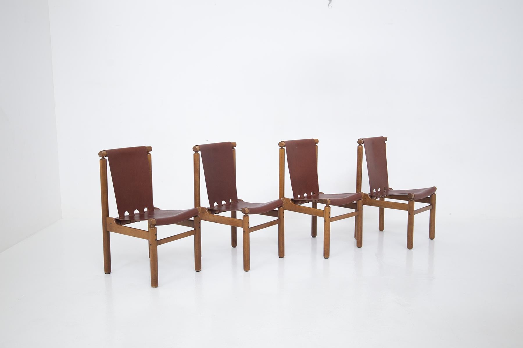 Ilmari Tapiovaara's eccentric set of four chairs for Permanente Mobili Cantu , 1950s. The set is made with a monumental wooden frame. In fact, the structure has well defined cylindrical and geometric shapes. Its particularity is the backrest and