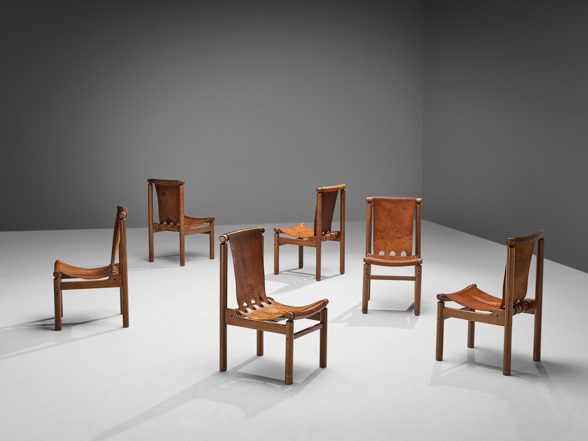 Ilmari Tapiovaara for La Permanente Mobili Cantù, darkened beech and patinated cognac leather, Finland, 1950s.

These robust chairs by Ilmari Tapiovaara feature a geometric frame for the patinated cognac leather seating and backrest. Besides the