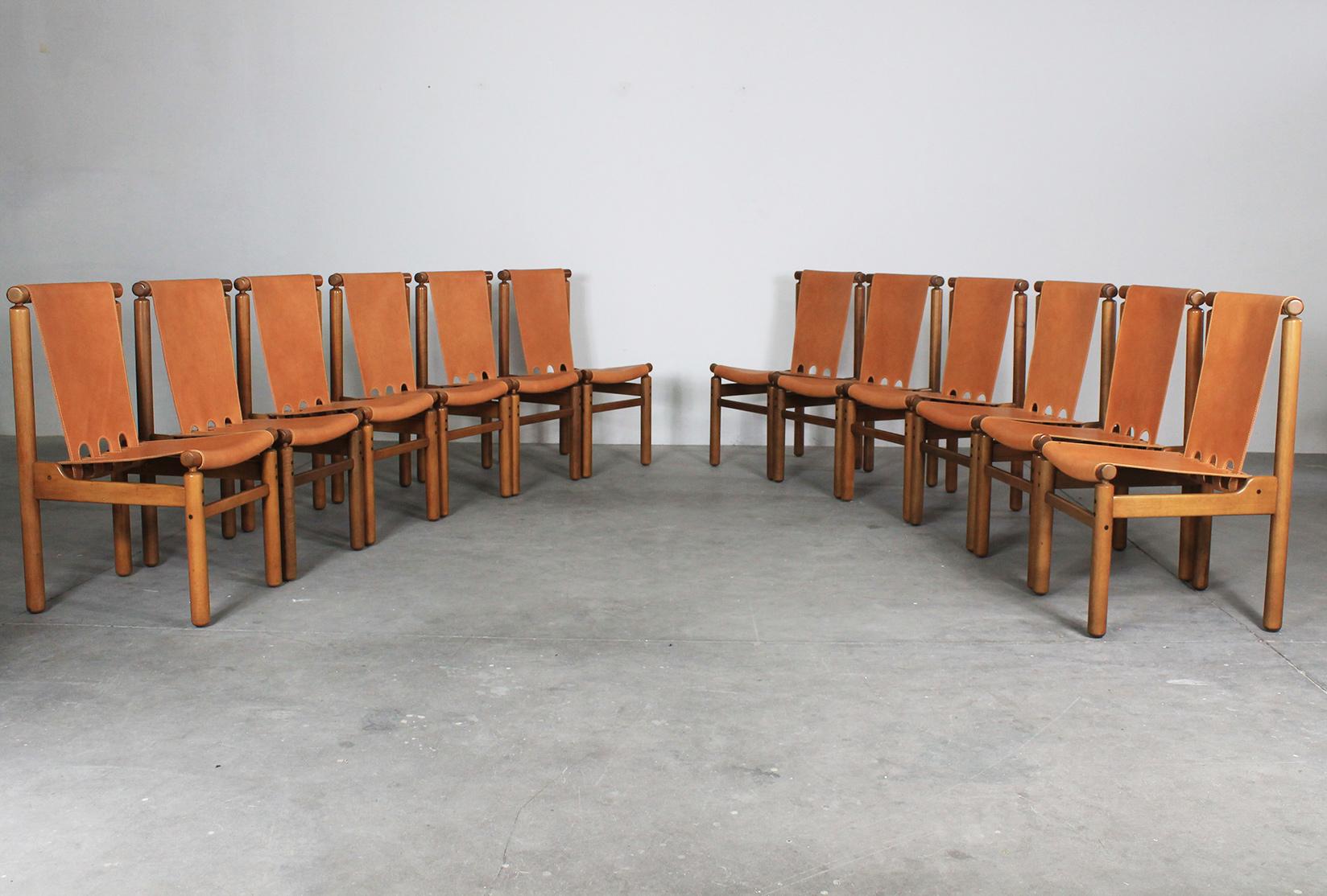 Set of twelve dining chairs with wooden frame, seat and back in leather designed by Ilmari Tapiovaara and produced by La Permanente Mobili Cantù in 1950s. 

This set of chairs presents a beautiful solid structure given by the geometrical shape of