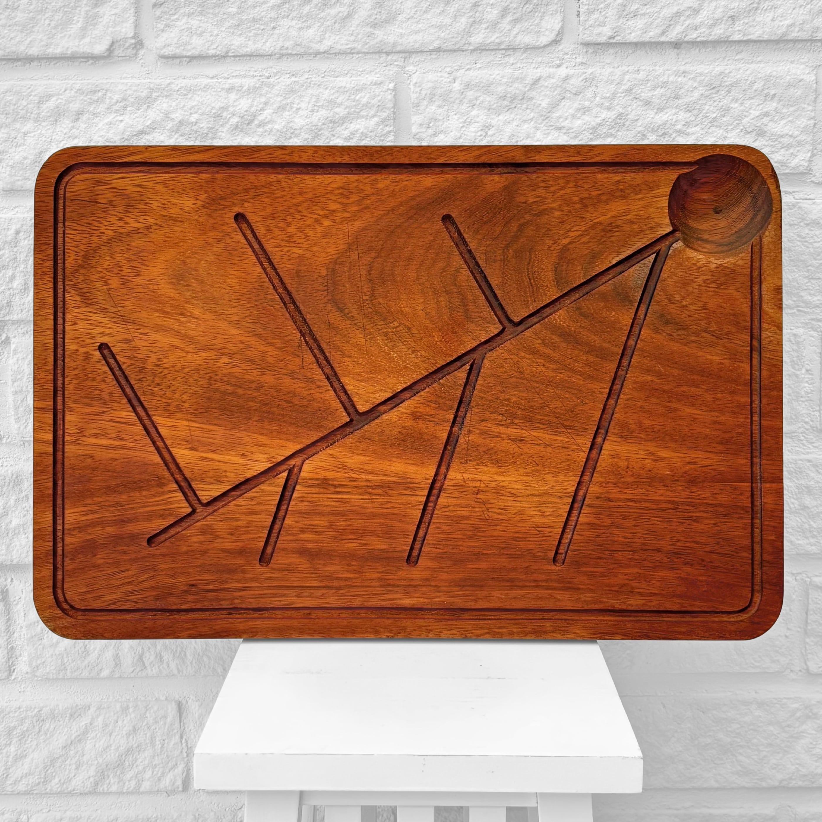 Una hermosa tabla de cortar o bandeja para servir, fabricada en teca maciza y con un dibujo en relieve de una rama de árbol. Diseñado en la década de 1960 por el arquitecto finlandés Ilmari Tapiovaara para Artek, Finlandia. Las ranuras para zumo