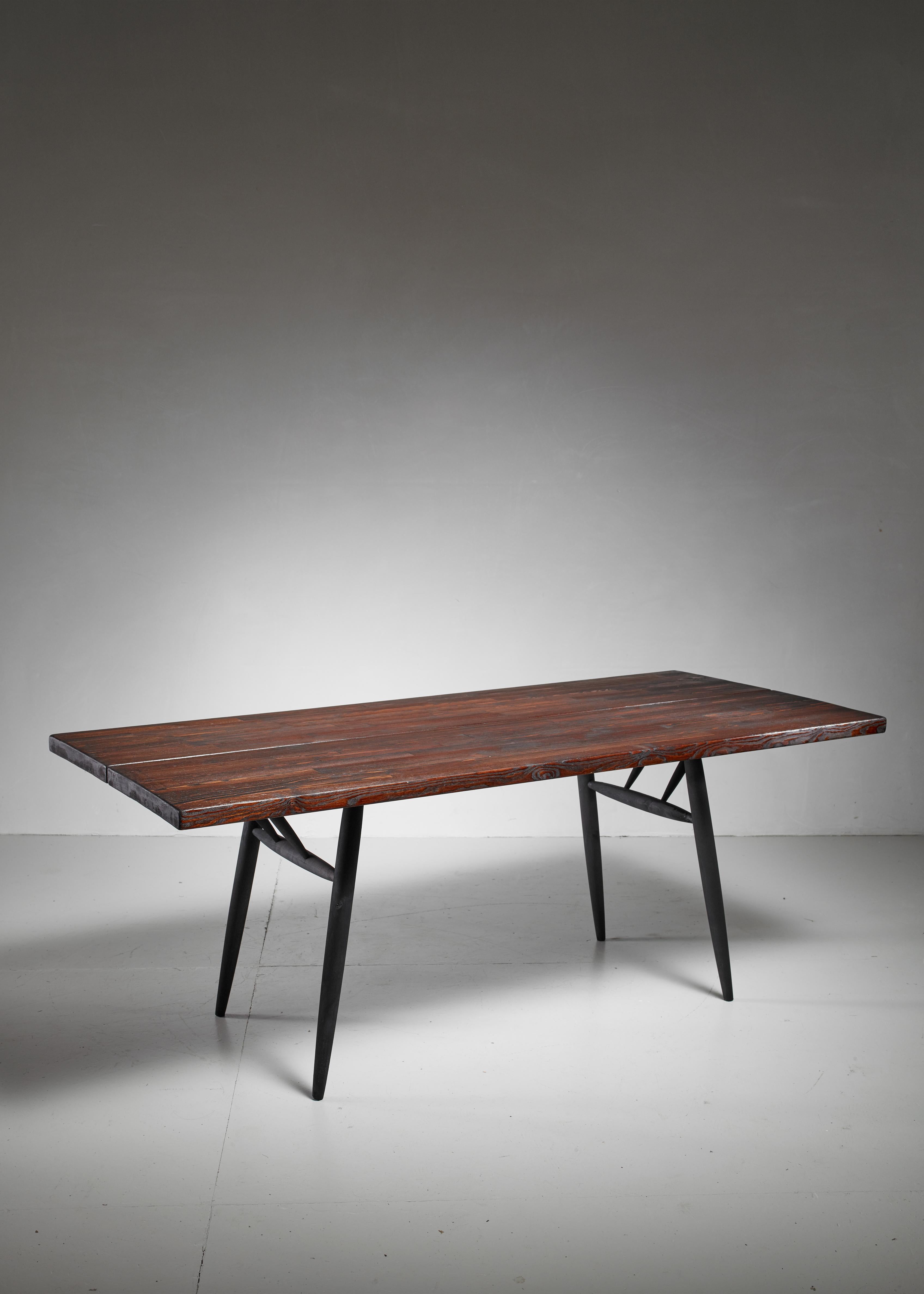 A stained pine dining table by Ilmari Tapiovaara for Laukaan Puu. Marked by Laukaan Puu and in a very good condition with a wonderful patina.