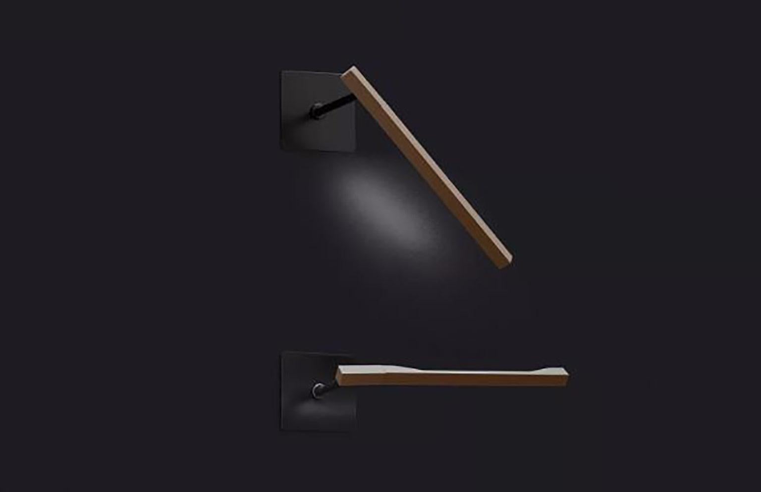 Lámpara de pared Ilo de David Lopez Quincoces para Oluce. La sencillez de su diseño y su ligereza hacen de esta lámpara una pieza destacada del diseño funcional. La fuente de luz está alojada en una barra cromada de diseño esbelto y montada en la