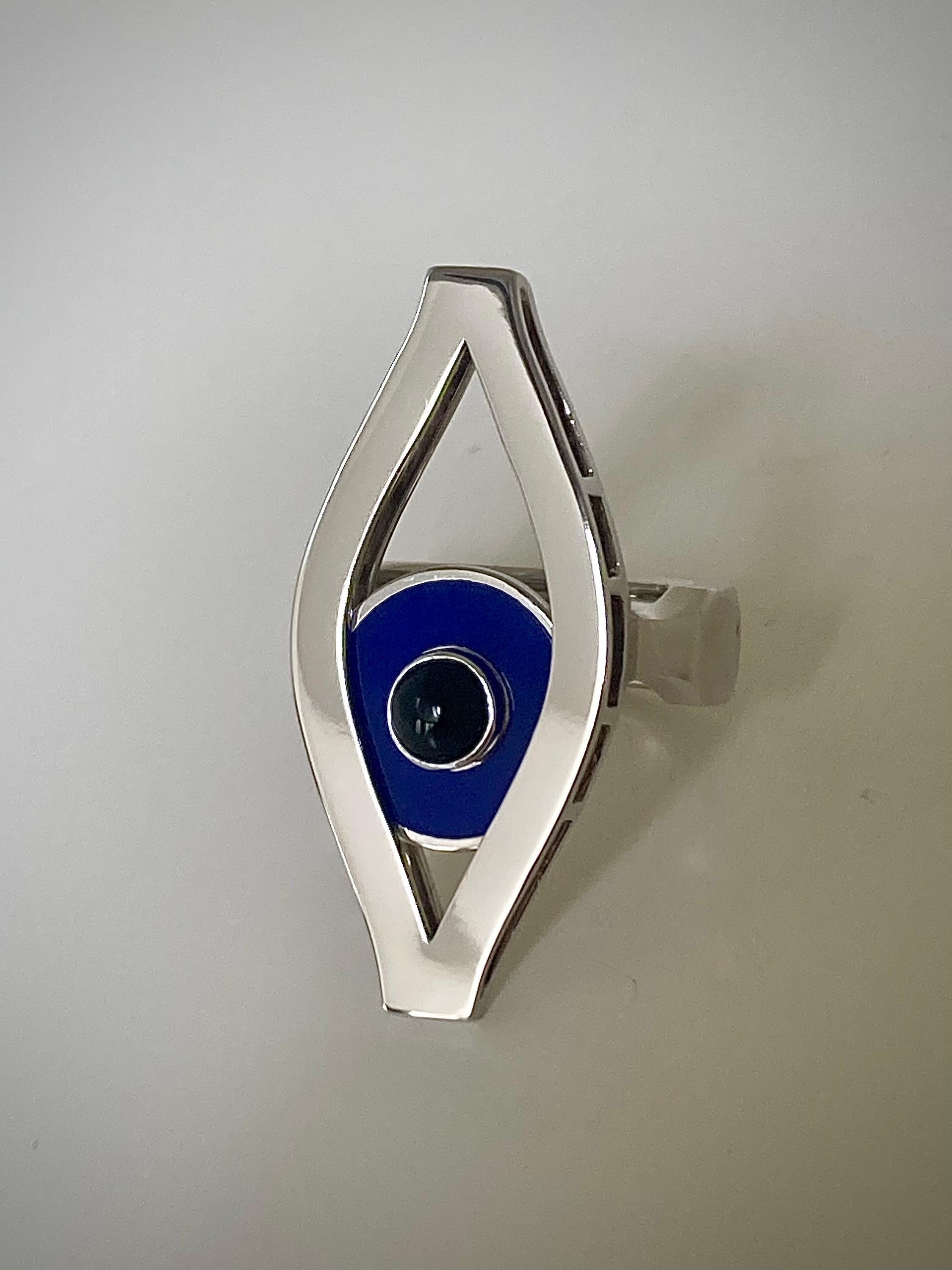 Bague cinétique Third Eye d'Ilona Orel en or blanc 18k avec une pupille mobile en laque bleue, qui glisse avec le mouvement de la main.
 Les bijoux cinétiques ne se limitent pas à la beauté du mouvement, ils ajoutent également un élément ludique aux