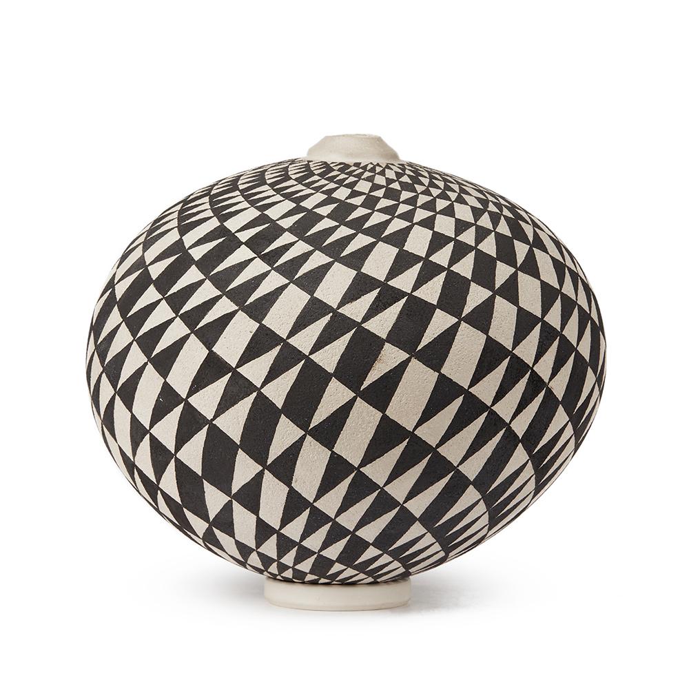 A stunning Czech, Ilona Sulikova Raku fired black and white ceramic studio pottery vase decorated with a swirling triangular pattern with a small matching circular stand. The rounded vase has a narrow raised neck and is fired and then completed by