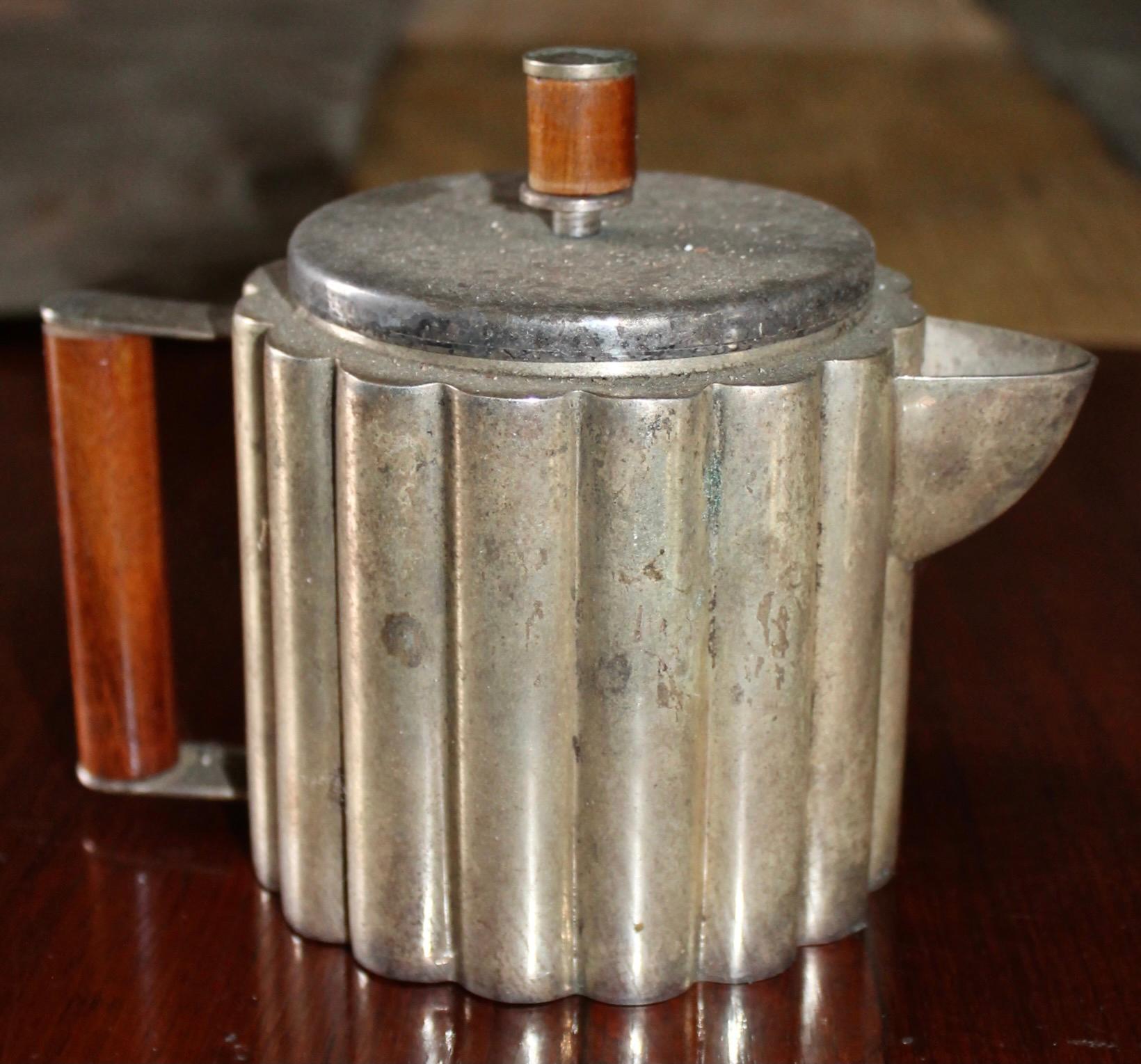 Machin Age kleine Teekanne hergestellt von Paye & Baker 1928. Vernickelt
Messing mit Holzknauf.  Unsigniert und ungereinigt. Entworfen von der berühmten ungarischen/amerikanischen Künstlerin/Designerin Ilonka Karasz, die vor allem durch ihre