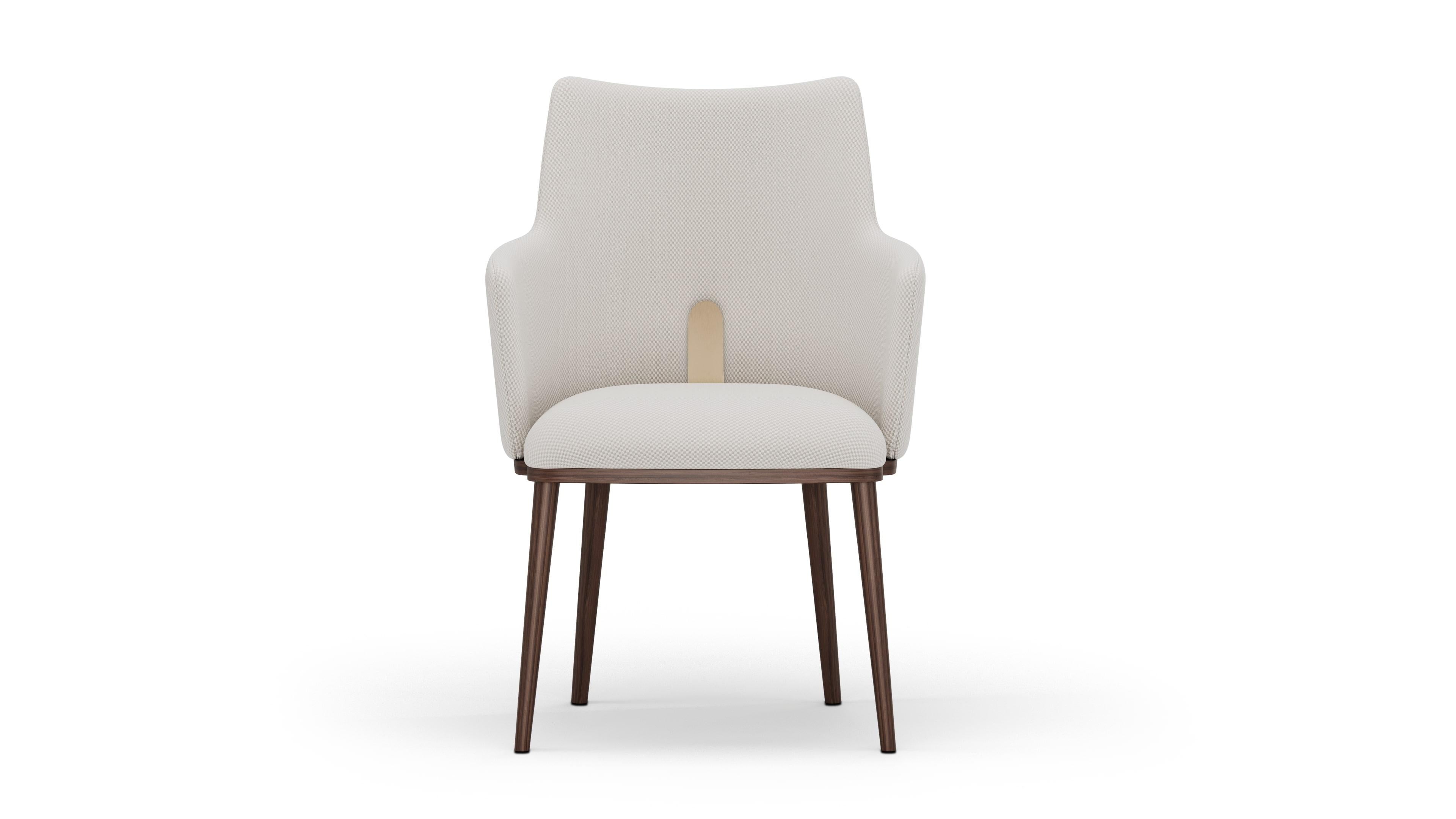 Ilora chair is a refined expression of modern elegance, where clean lines meet subtle detail. Wrapped in soft cream fabric, the chair’s silhouette is graceful yet grounded, supported by solid walnut legs that showcase the warmth of natural wood. A
