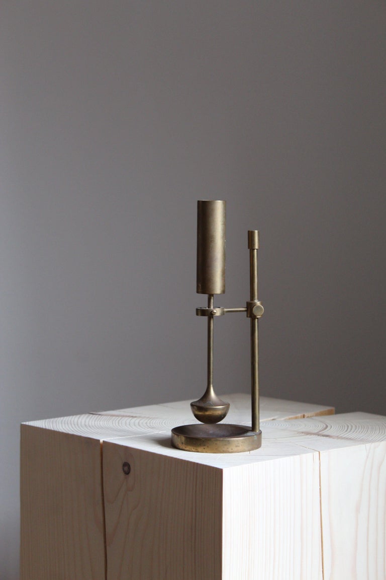A sculptural adjustable candlestick designed and produced by Ilse D. Ammonsen. Denmark, 1960s. For Daproma Design. Signed and with paper label. The ingenious construction keeps the candle level when the candlestick is moved, centering the candle
