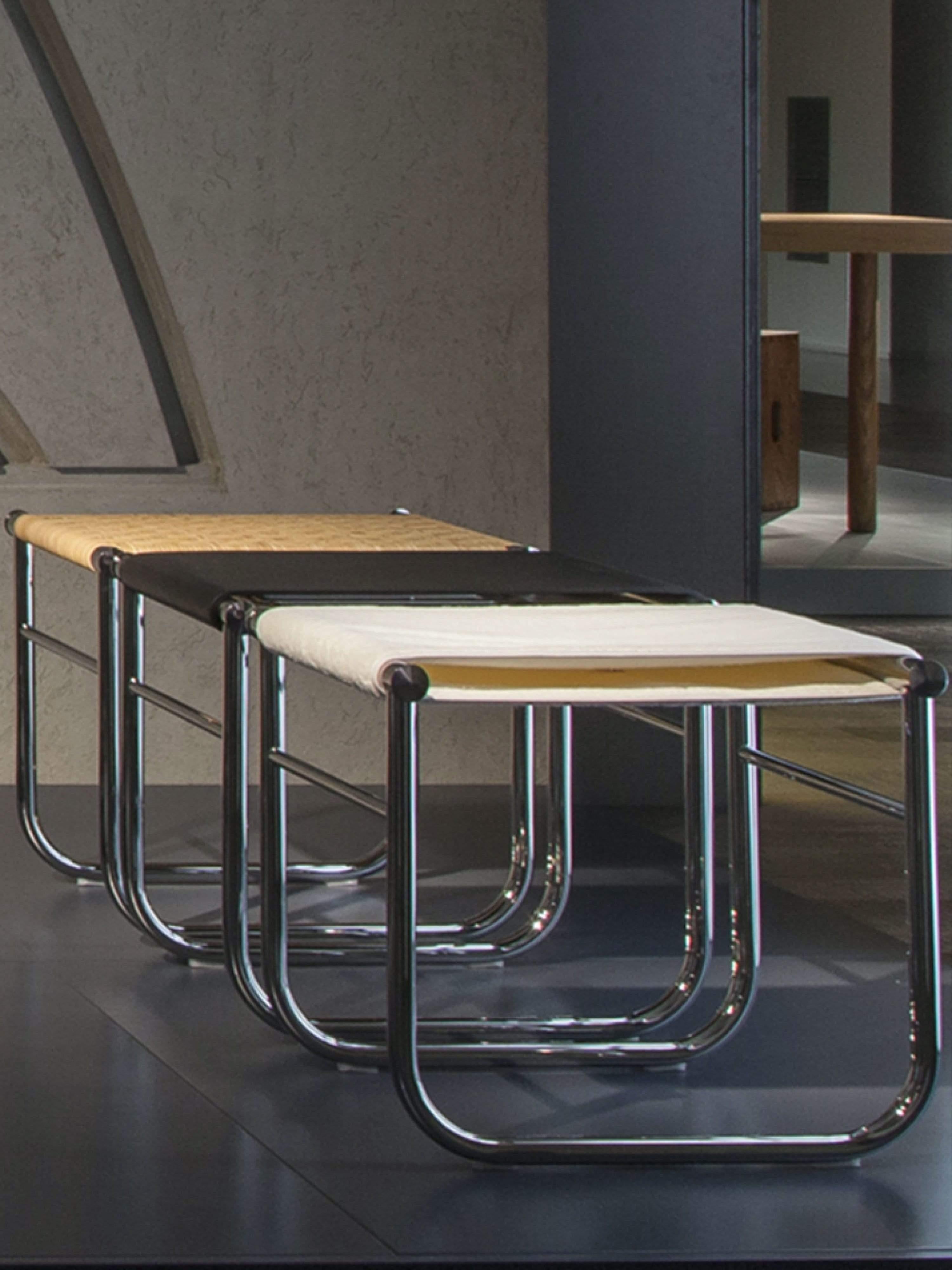 El icónico Taburete iMaestri Le Corbusier 9 Blanco, diseñado por Charlotte Perriand, es un mueble atemporal fabricado con una estructura de acero inoxidable cromado y materiales de primera calidad. El revestimiento del asiento está hecho de un suave