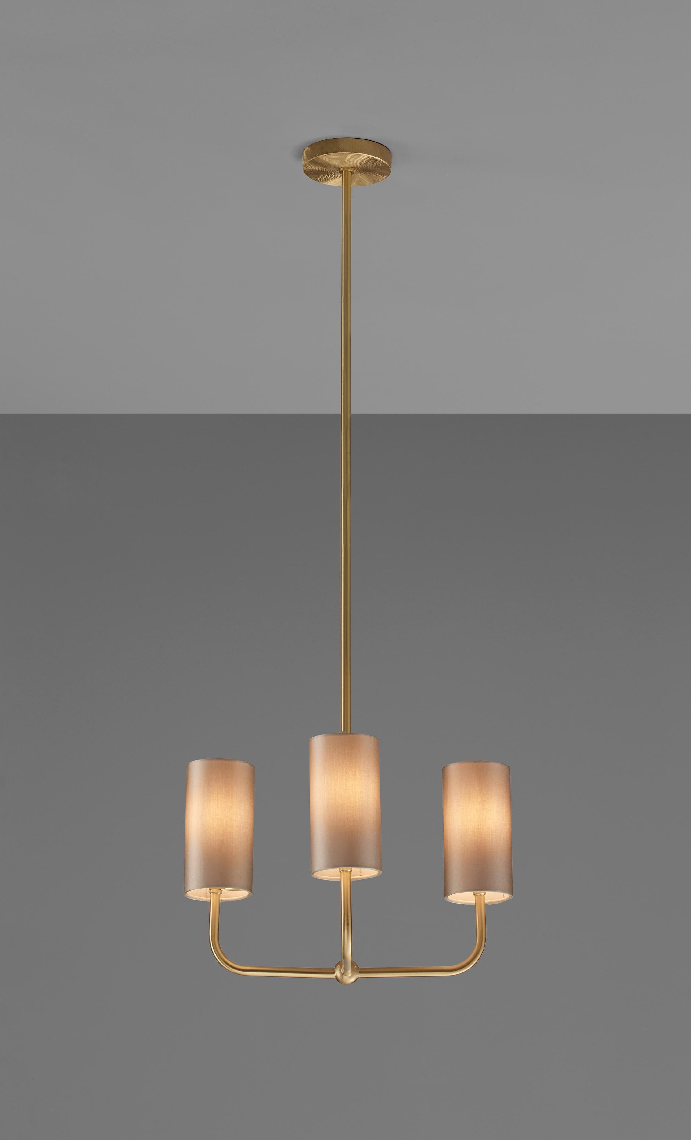 This pendant is a modern take on tradition. Beautifully crafted with elegant materials including brushed brass and sateen shades. The tall, timeless shades add a modern touch to the classic motif base, giving a familiar, yet forward looking