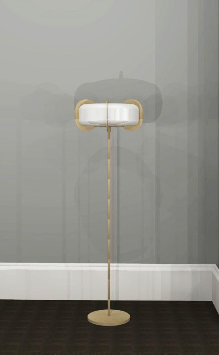 Art Deco form, but Minimalist design remains. This floor lamp is crafted from solid brass and white glass. A sculptural design formed from elegant oval frosted glass shade with brushed brass discs connected to the top and bottom diffusers that go