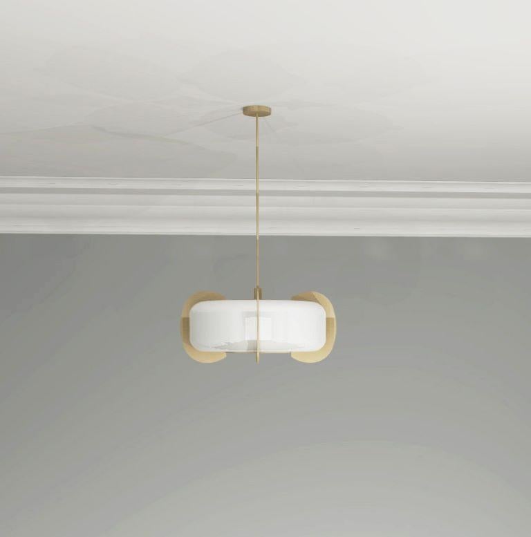 Art Deco form, but minimalist design remains. This pendant is crafted from solid brass and white glass. A sculptural design formed from elegant oval frosted glass shade with brushed brass discs connected to the top and bottom diffusers that go