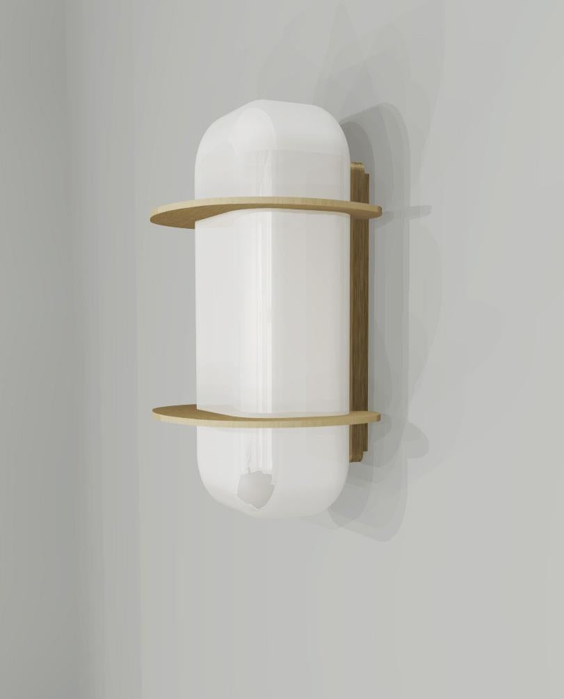 Art Deco form, but minimalist design remains. This wall light is crafted from solid brass and white glass. A sculptural design formed from elegant oval frosted glass shade with brushed brass discs connected to the top and bottom diffusers that go