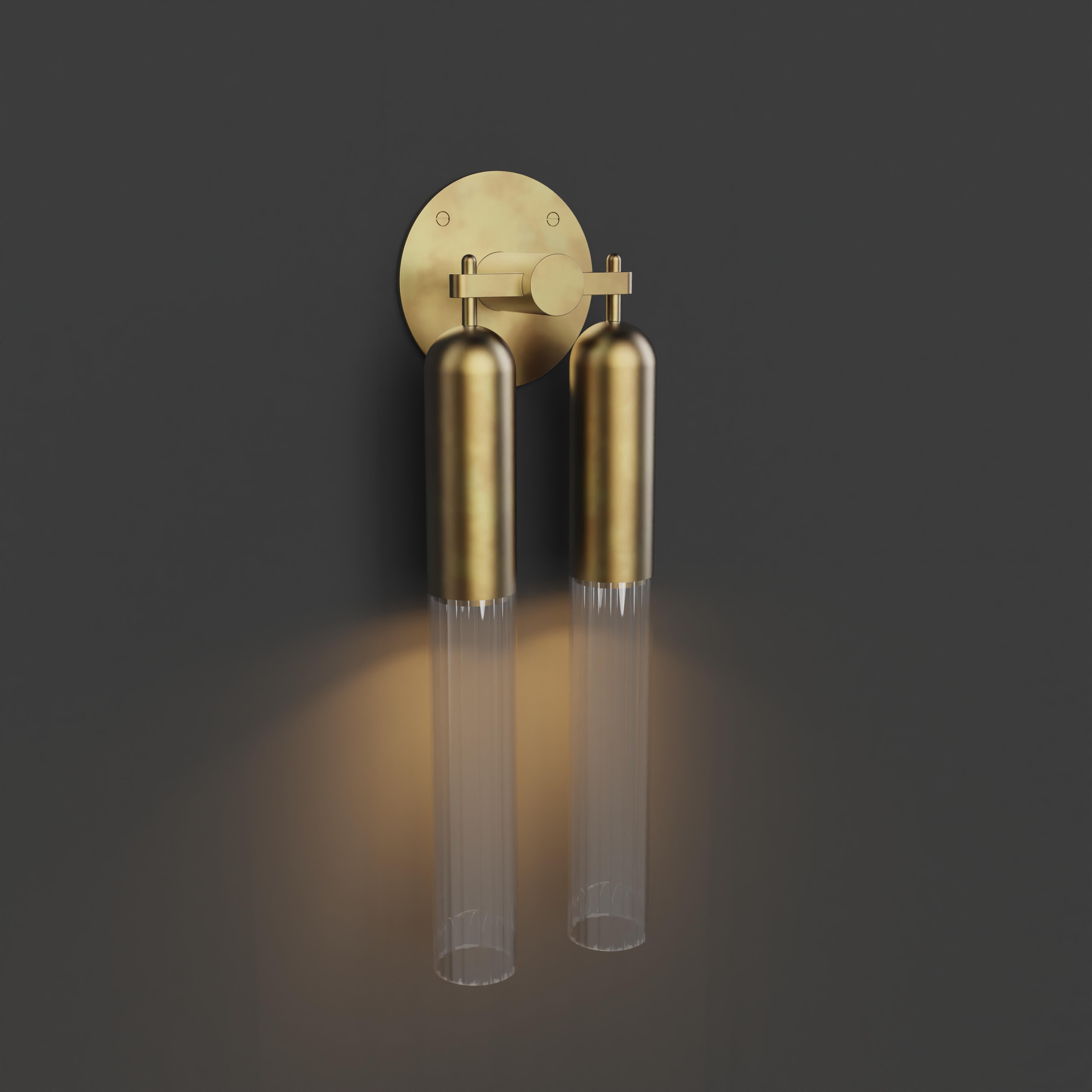Double Wall Light in brushed brass metal finish with fluted glass shade. 

Dimensions:
Overall Height: 500mm 
Glass Dia: 60mm 
Overall projection: 108mm 
Width: 160mm
Integrated LED

Made to order to buyer's specification. Variations to dimensions