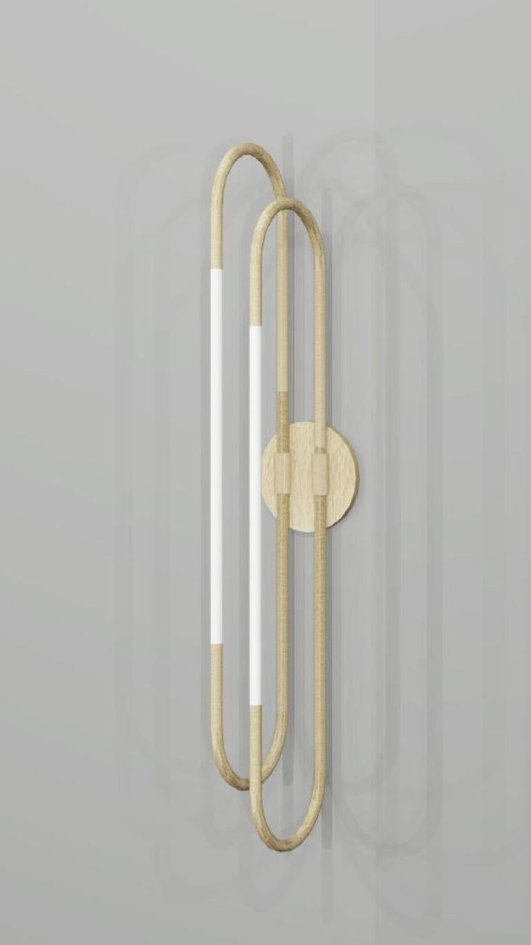 This wall light is based on infinite loops of brass, coiling continuously to create a free and fluid structure, with subtly integrated lighting elements.
Finish: brushed brass and opal glass.
Height: 530mm
Projection: 110mm
Rod Dia: 15mm

Made to