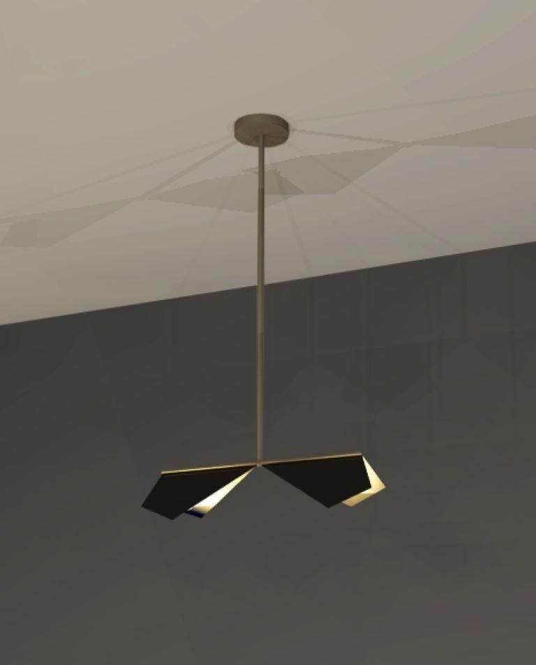 Design and crafted by world-renowned lighting brand IMAGIN, and inspired from observing bats while on vacation, this pendant combines a simple folded brass shade along with a long arm brass base. The topside of the shade finished in matt black and