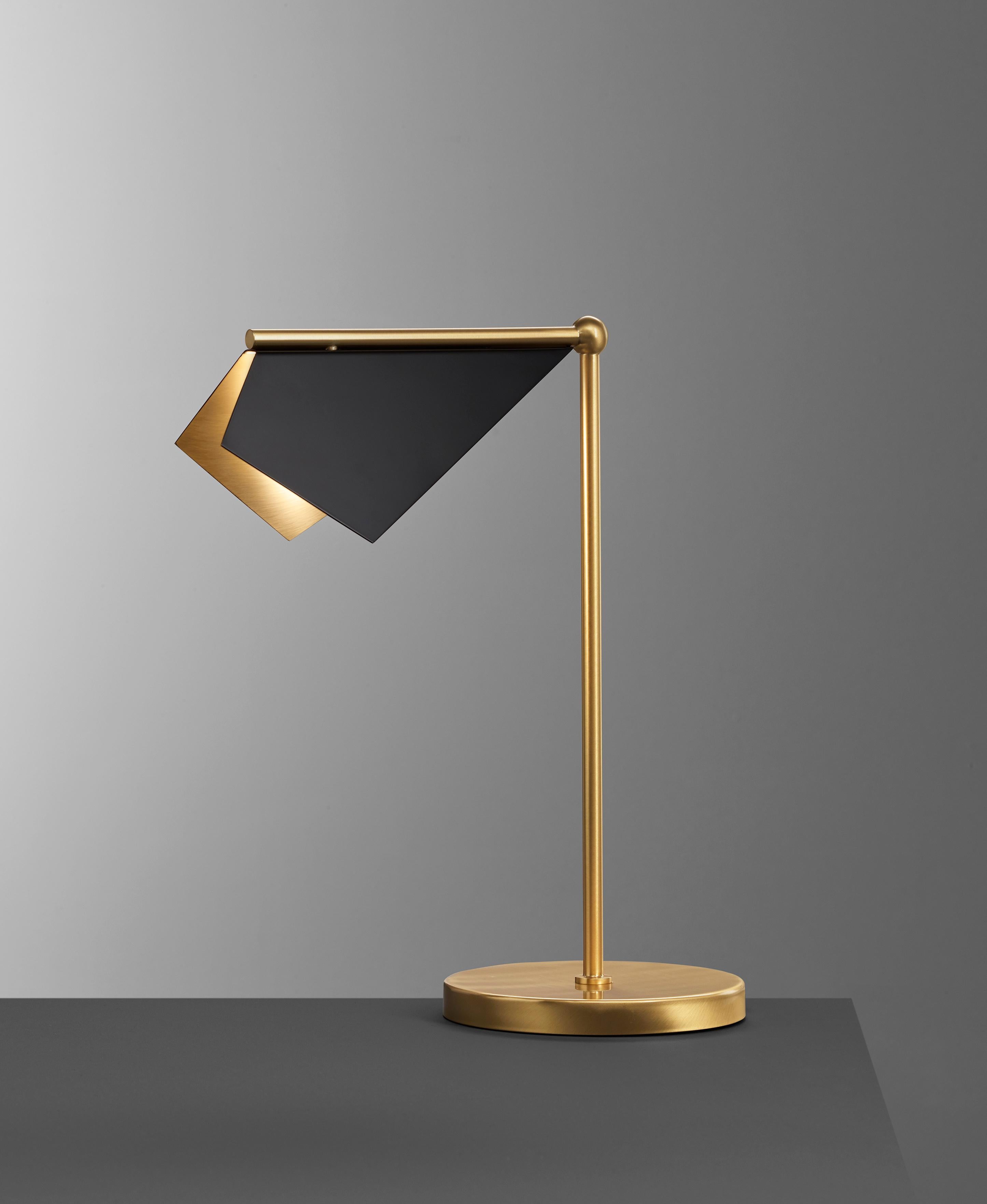 Design and crafted by world-renowned lighting brand IMAGIN, and inspired from observing bats while on vacation, this table lamp combines a simple folded brass shade along with a long arm brass base. The topside of the shade finished in matt black