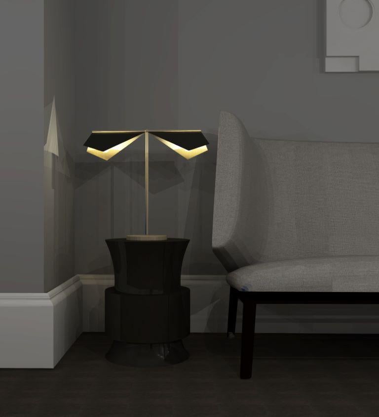 Design and crafted by world-renowned lighting brand IMAGIN, and inspired from observing bats while on vacation, this double table lamp combines a simple folded brass shade along with a long arm brass base. The topside of the shade finished in matt