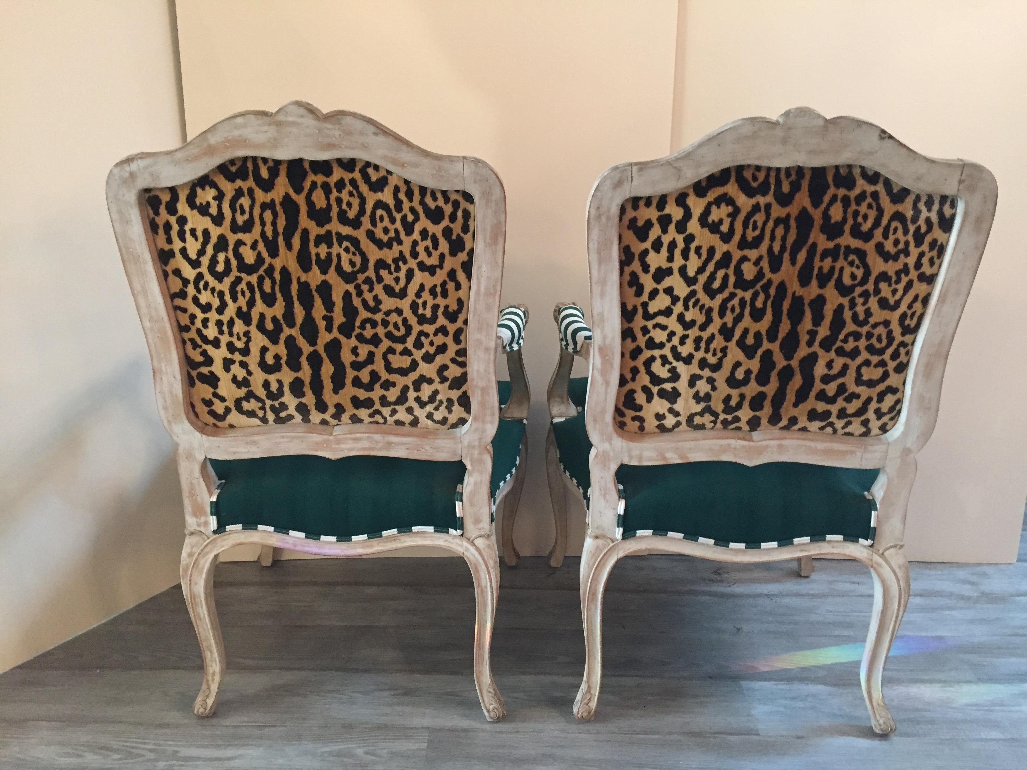 Stylish pair of creamy white painted carved wood French style armchairs having wonderfully clever upholstery. The fronts are green blended cotton detailed with green and white striped welting and arm pads, while the back is a glam faux leopard.

 