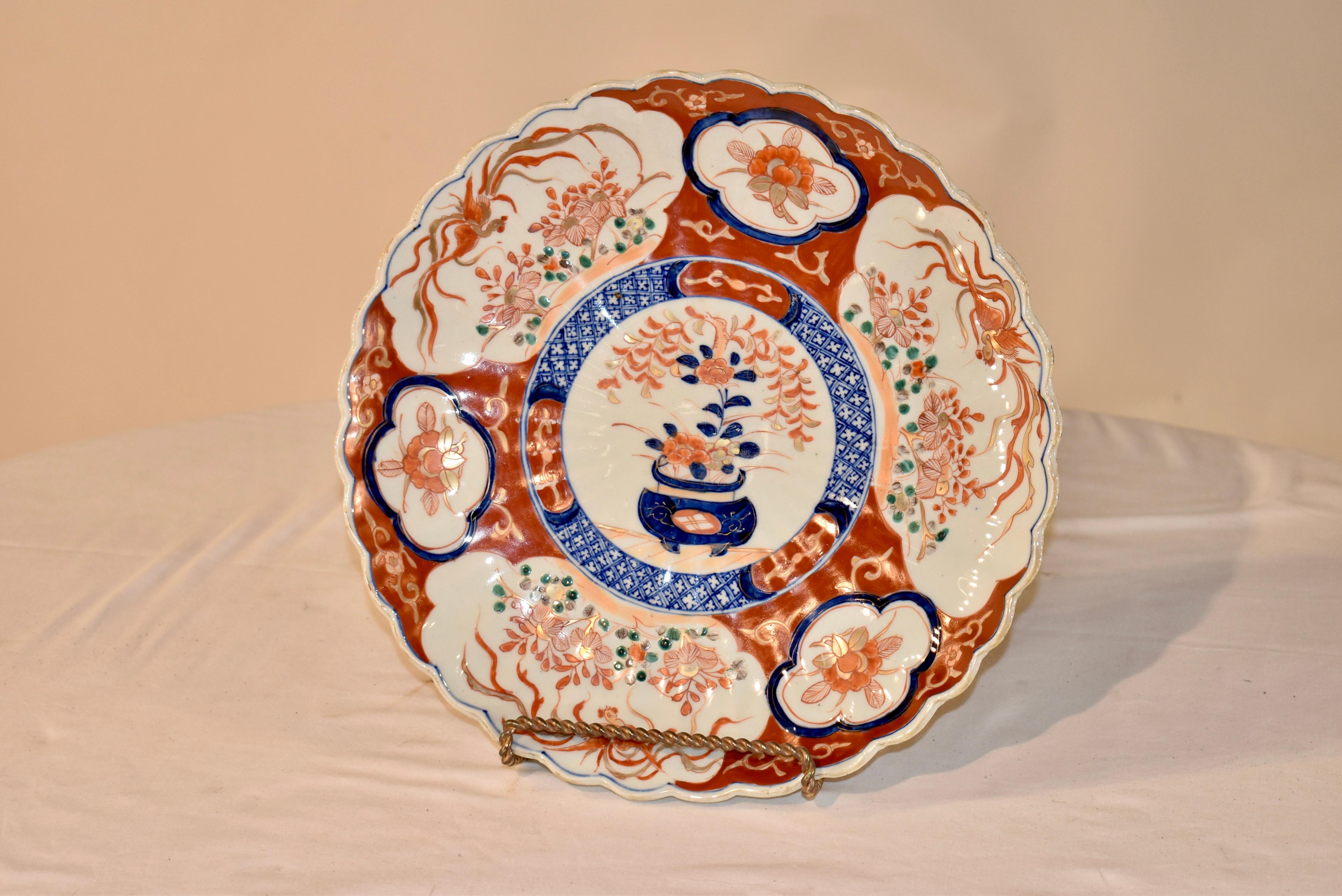 Circa 1900 Imari charger from Japan with a central medallion, containing a hand painted picture of a potted plant, surrounded by three larger medallions containing florals and birds.  These medallions are separated by smaller medallions with floral