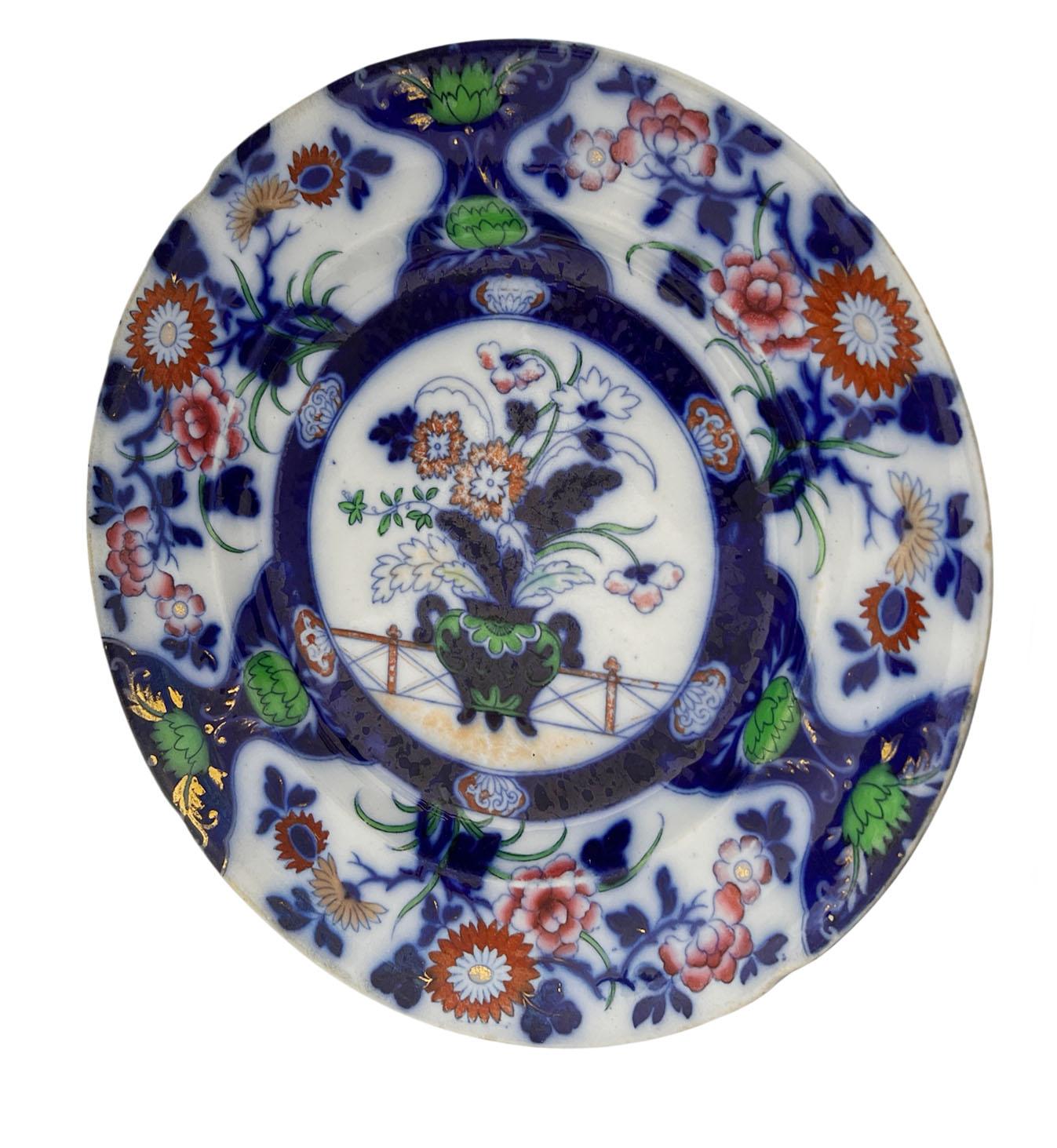 Hicks & Meigh enameled Imari ironstone plate in cobalt, vivid green and iron red. Center vase with chrysanthemums, peonies and blossoms. Blue underglaze on reverse with mark and numbered 3/1053. Regency period, England, circa 1822 - 1835.