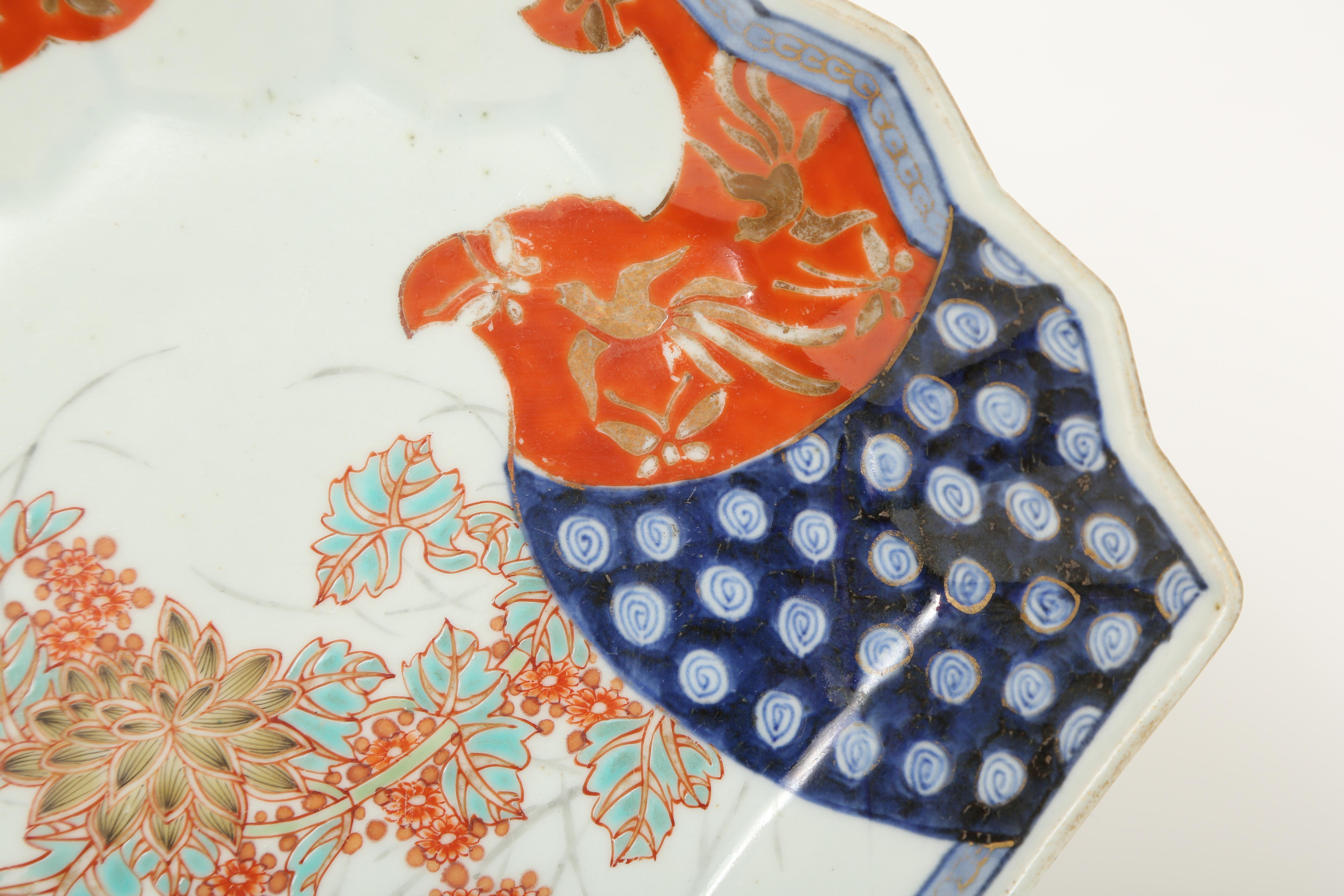 Imari fan shaped Meiji Period porcelain serving plate. It has been decorated by hand in an underglaze blue and overpainted in iron red, aqua and gold. This asymetrically designed piece could be beautifully displayed on a stand or attractive enough