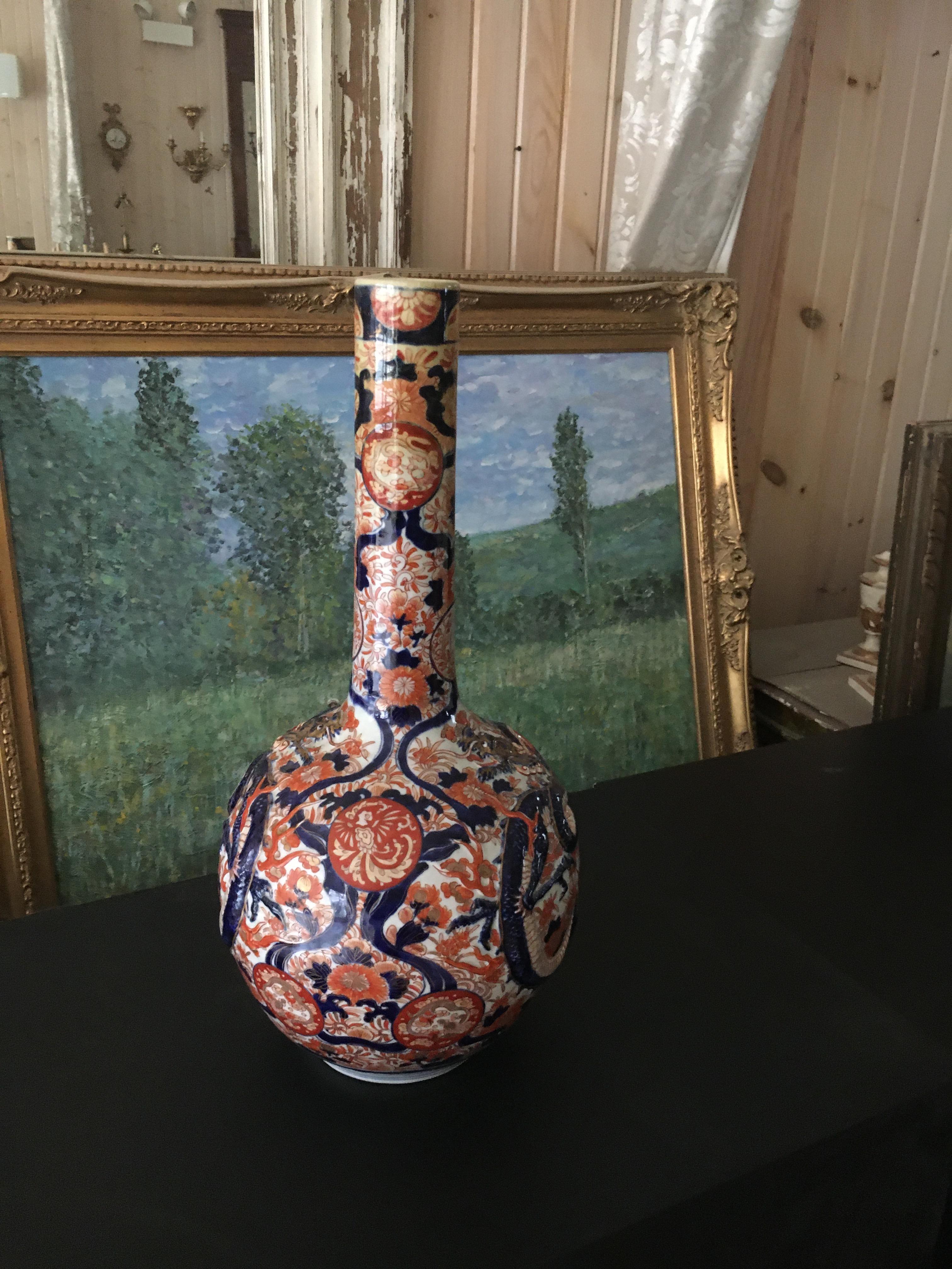 An Imari Porcelain bottle vase.  Very nicely done with great detail and three dimensional areas such as the dragons.  Part of a large collection including vases, chargers and bowls.